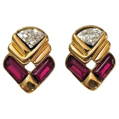 Pendientes de pasarela de Guy Laroche, con diseño geométrico en tono dorado y piedras rojas y transparentes
