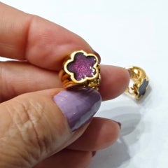 Pendientes de clip vintage de Guy Laroche en tono dorado con un detalle floral esmaltado en morado