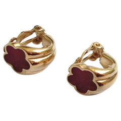 Pendientes de clip vintage de Guy Laroche en tono dorado con un detalle floral esmaltado en morado