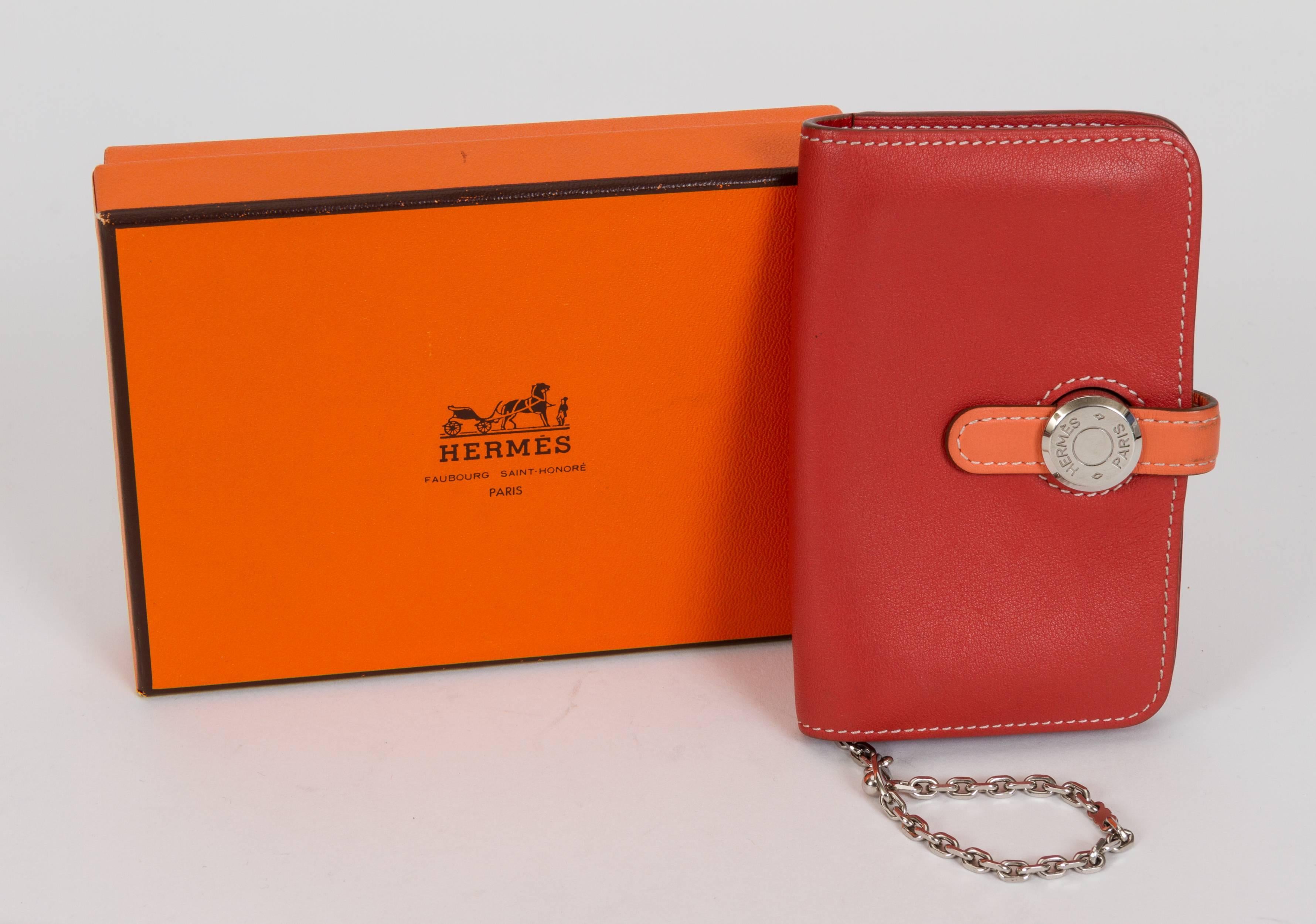 Hermès small dogon card wallet in bicolor swift leather and palladium hardware. Brick and coral combination. Date stamp Q for 2013. Comes with original box.
