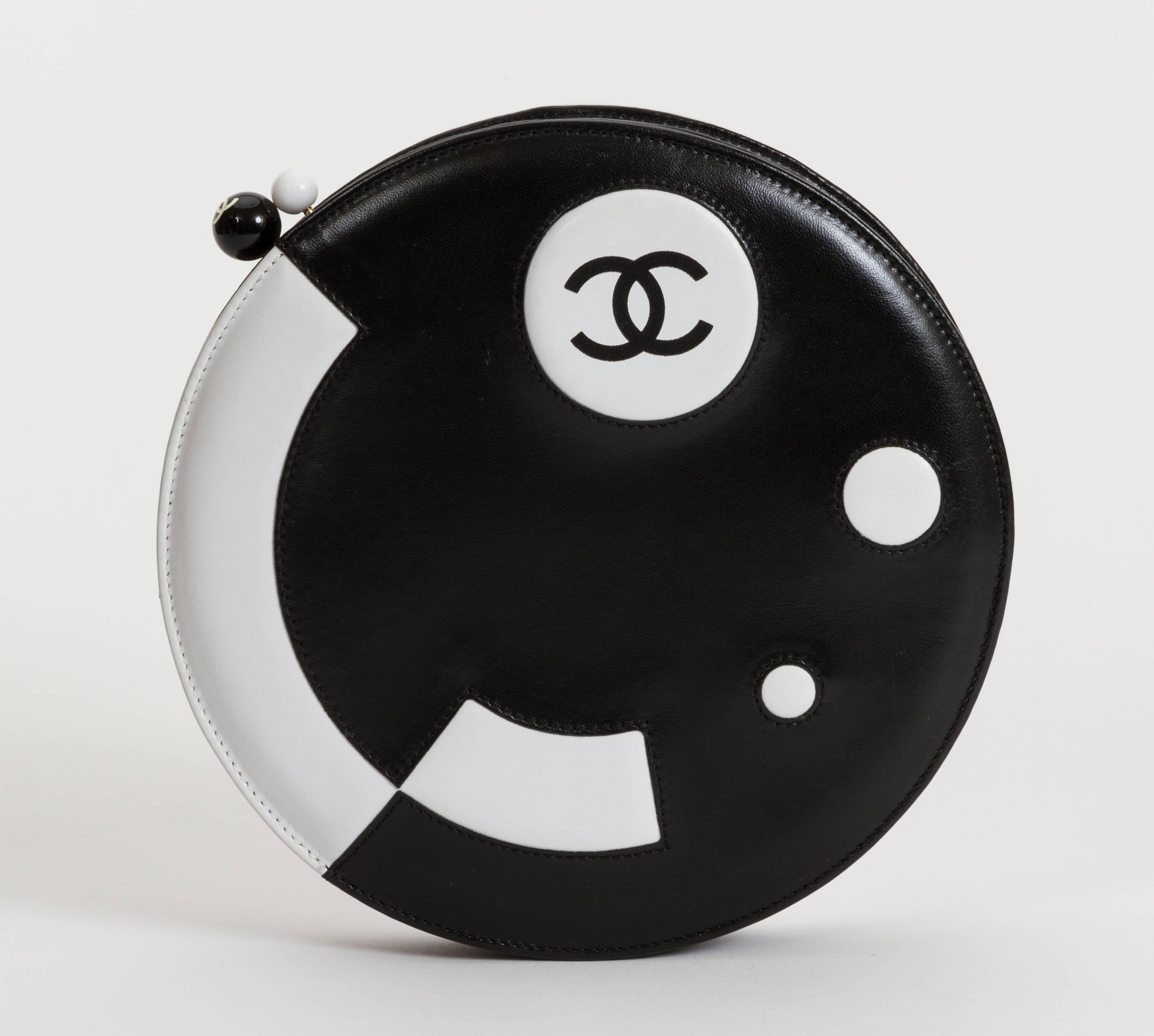 Chanel black and white rare round disc evening bag. Lucite kiss lock clasp. Collection 2002. Shoulder drop 13". Can be worn as a clutch or as a shoulder bag. Comes with hologram, id card, booklet, dust cover.
