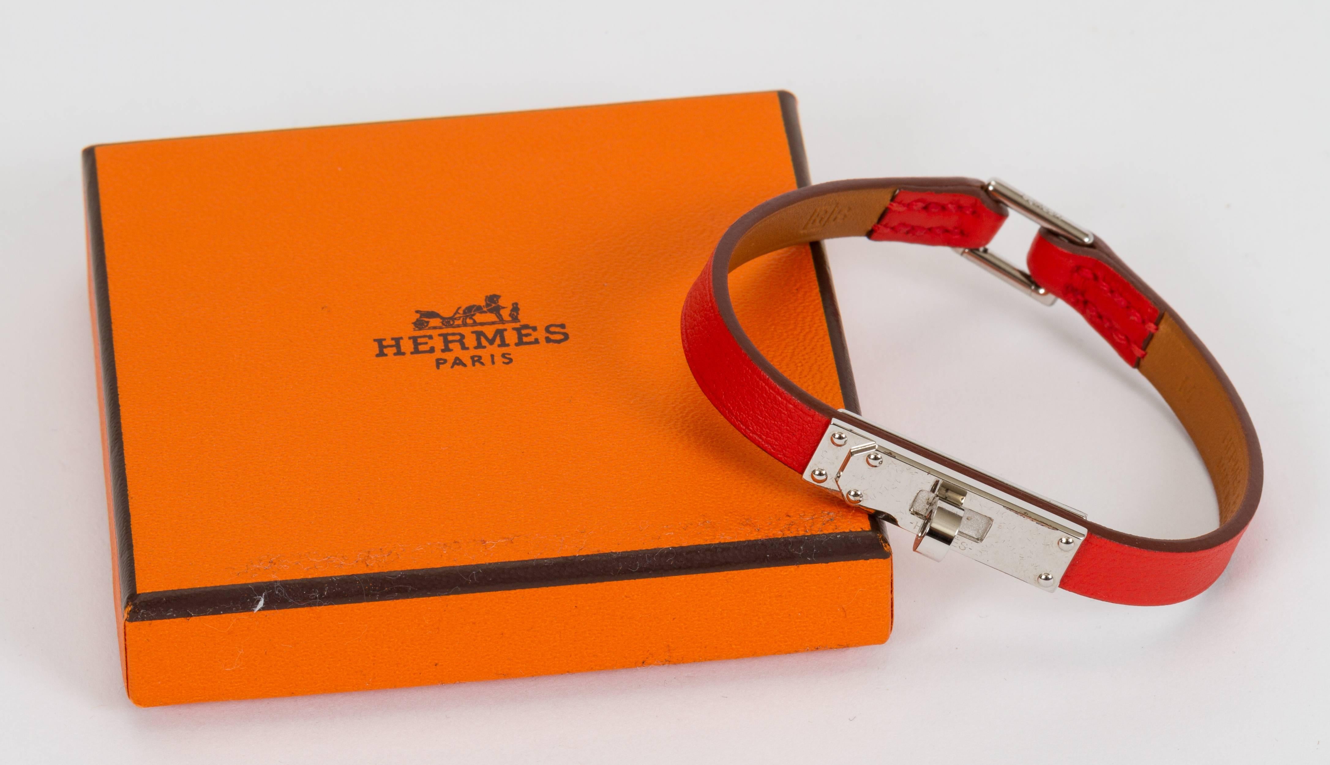 Hermès unworn mini kelly bracelet in capucine swift leather and palladium hardware. Size medium, Date stamp R for 2014. Comes with original duster and box.