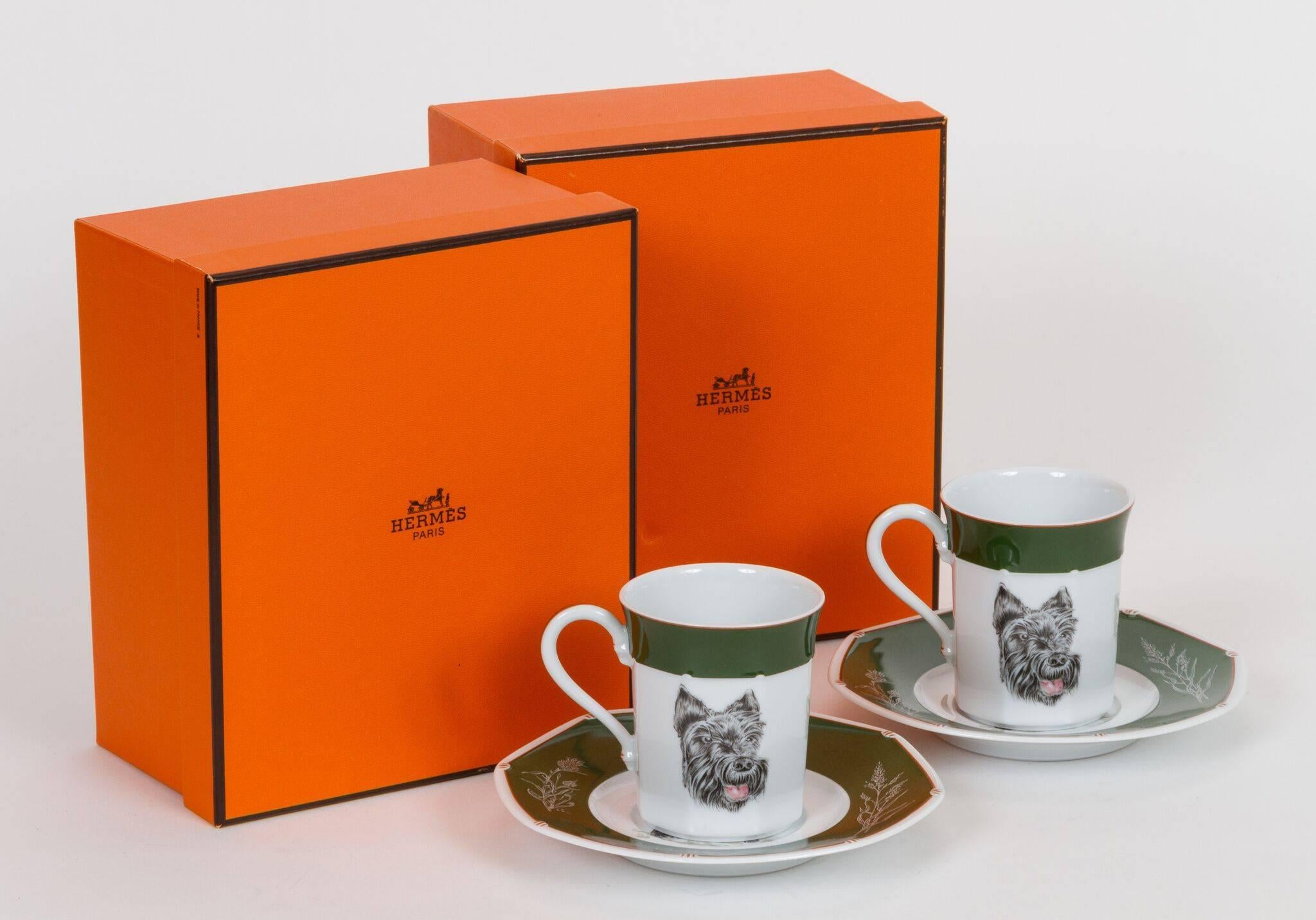 Set of two Hermès porcelain cups and saucers with Scottish Terrier design. Comes in original individual boxes and gift bag. Saucers, 6