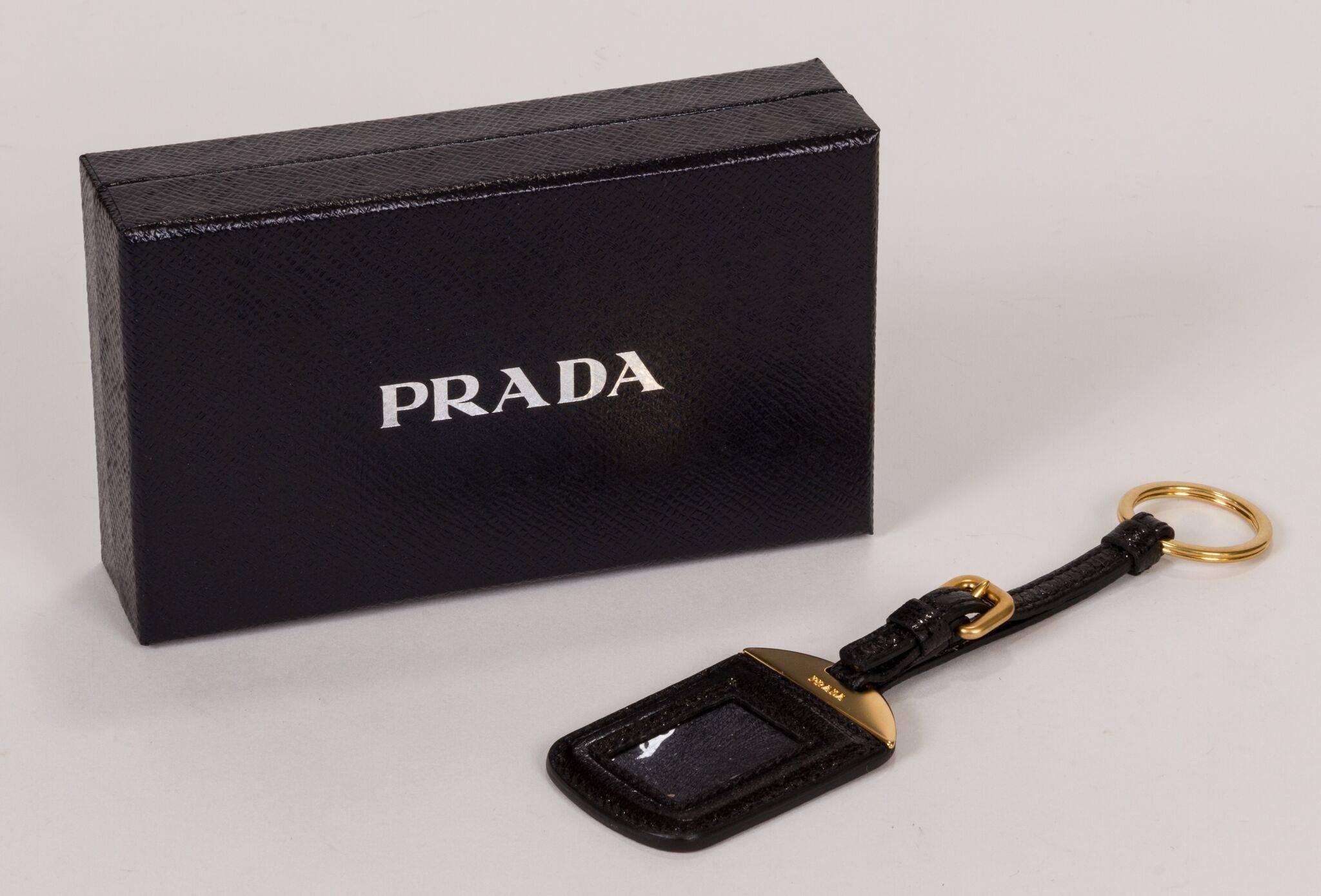 New 2014 Prada keychain and name tag holder. Black glossy leather and gold tone hardware. Comes with original box and tag.