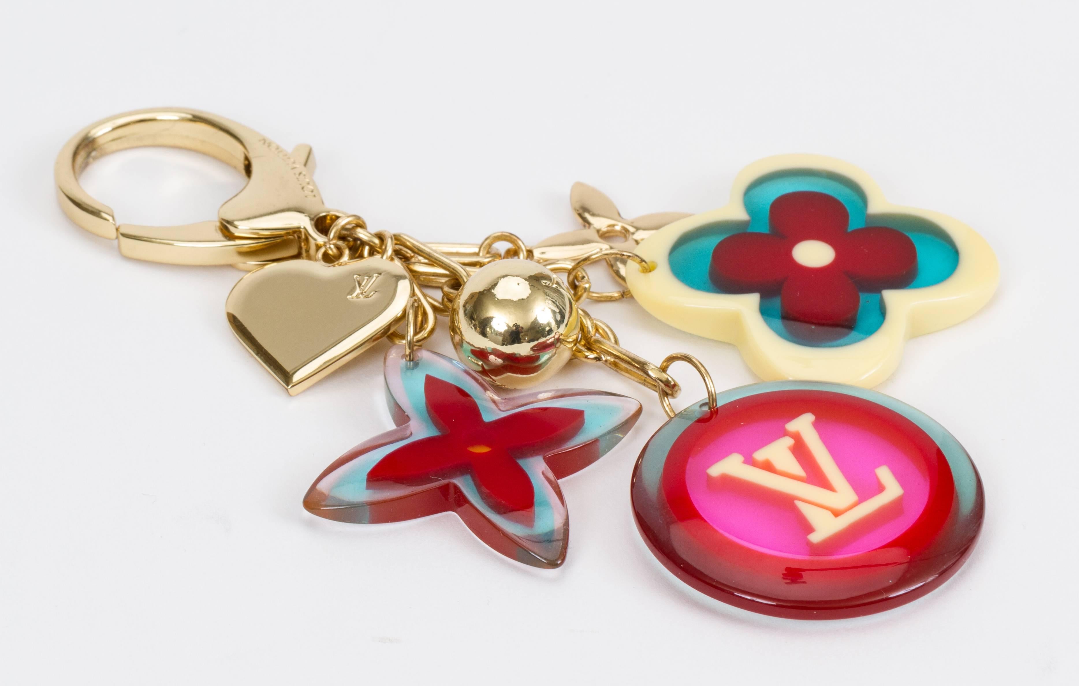 Louis Vuitton authentic bag charm /keychain with multicolor monogram symbols in lucite and gold tone metal. Comes with velvet pouch.
