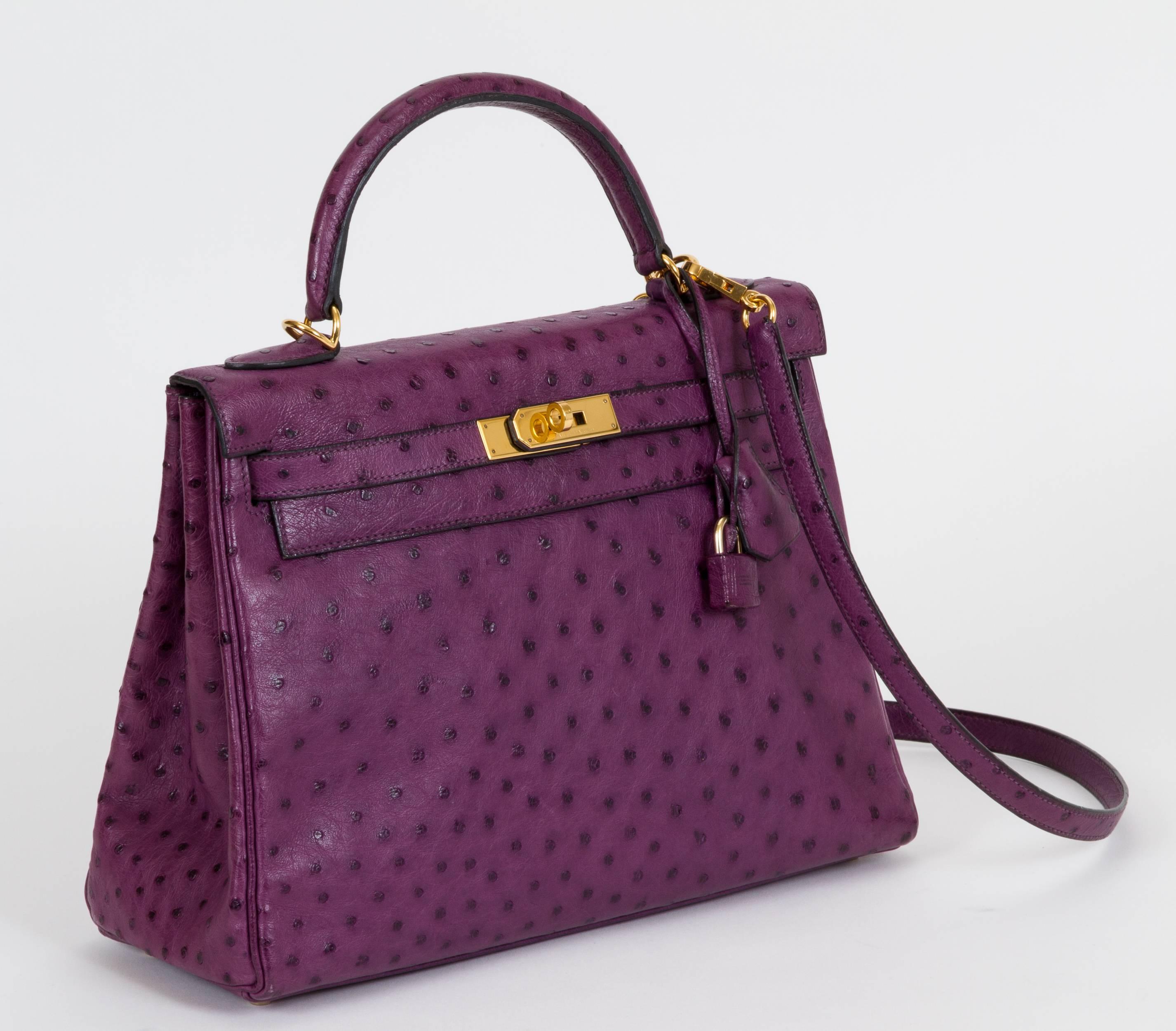 Hermès Kelly 32cm in ostrich leather. Iris purple color and goldtone hardware. Handle drop, 4"L. Date stamp J in a square, 2006. Comes with clochette, tirette, covered lock, keys, original dust bag and gift bag.
