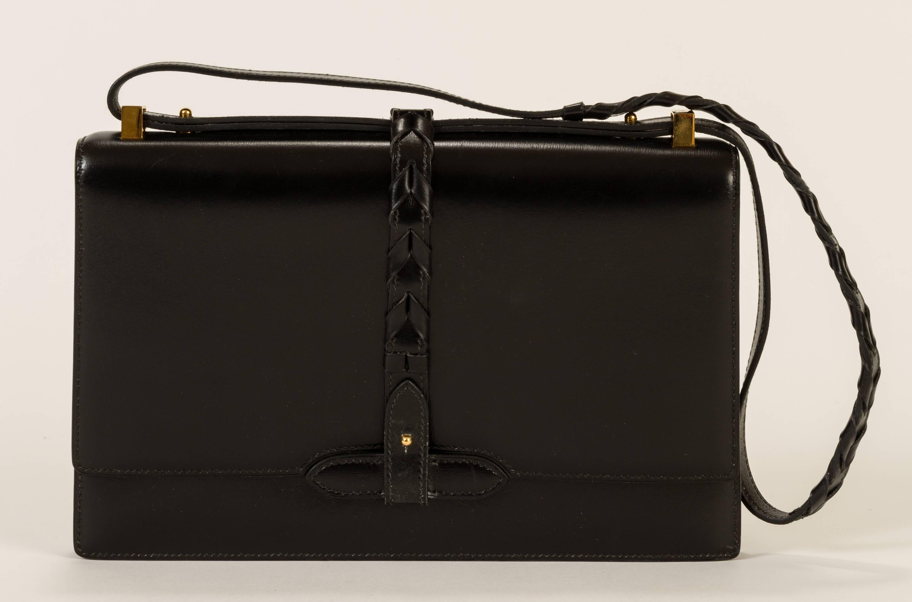 Vintage Hermès black leather shoulder bag with gold-plated hardware, leather interior and multiple interior pockets. Braided strap detaches to make the bag a clutch. Handle drop, 11