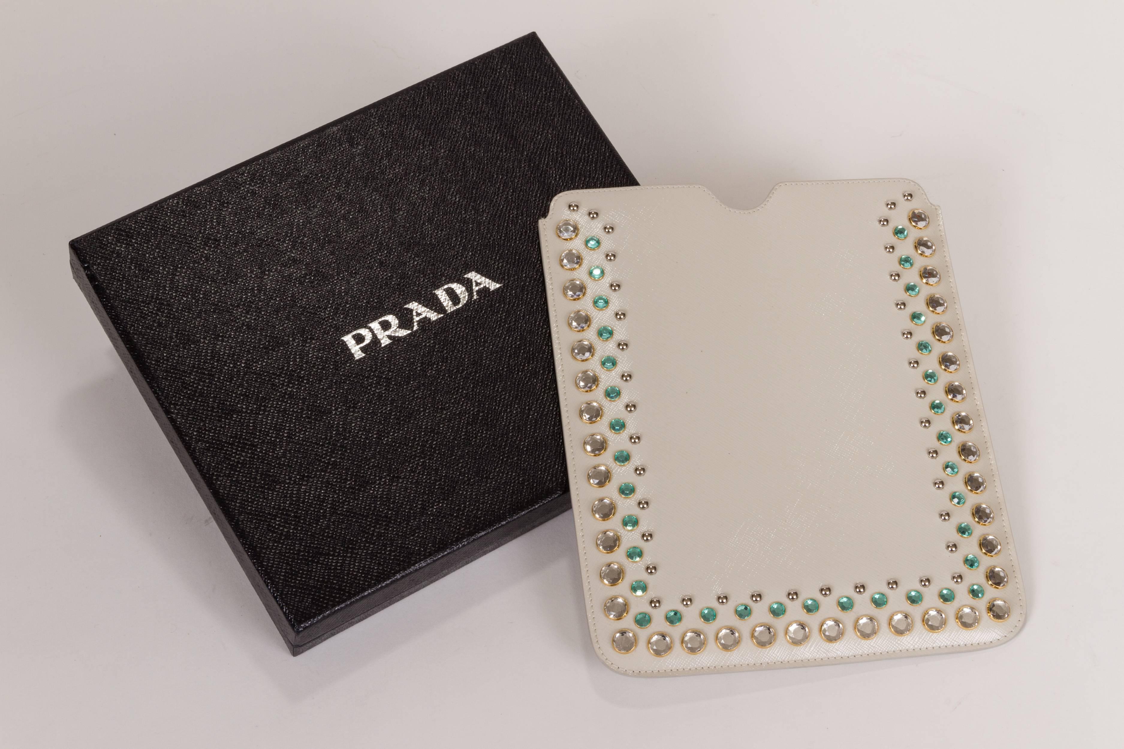 New with tags, bejeweled ipad cover case. Glossy saffiano leather in creamy white with green jewels.Butter lambskin leather interior. Gold tone Prada lettering. Comes with original box, warranty and tag.