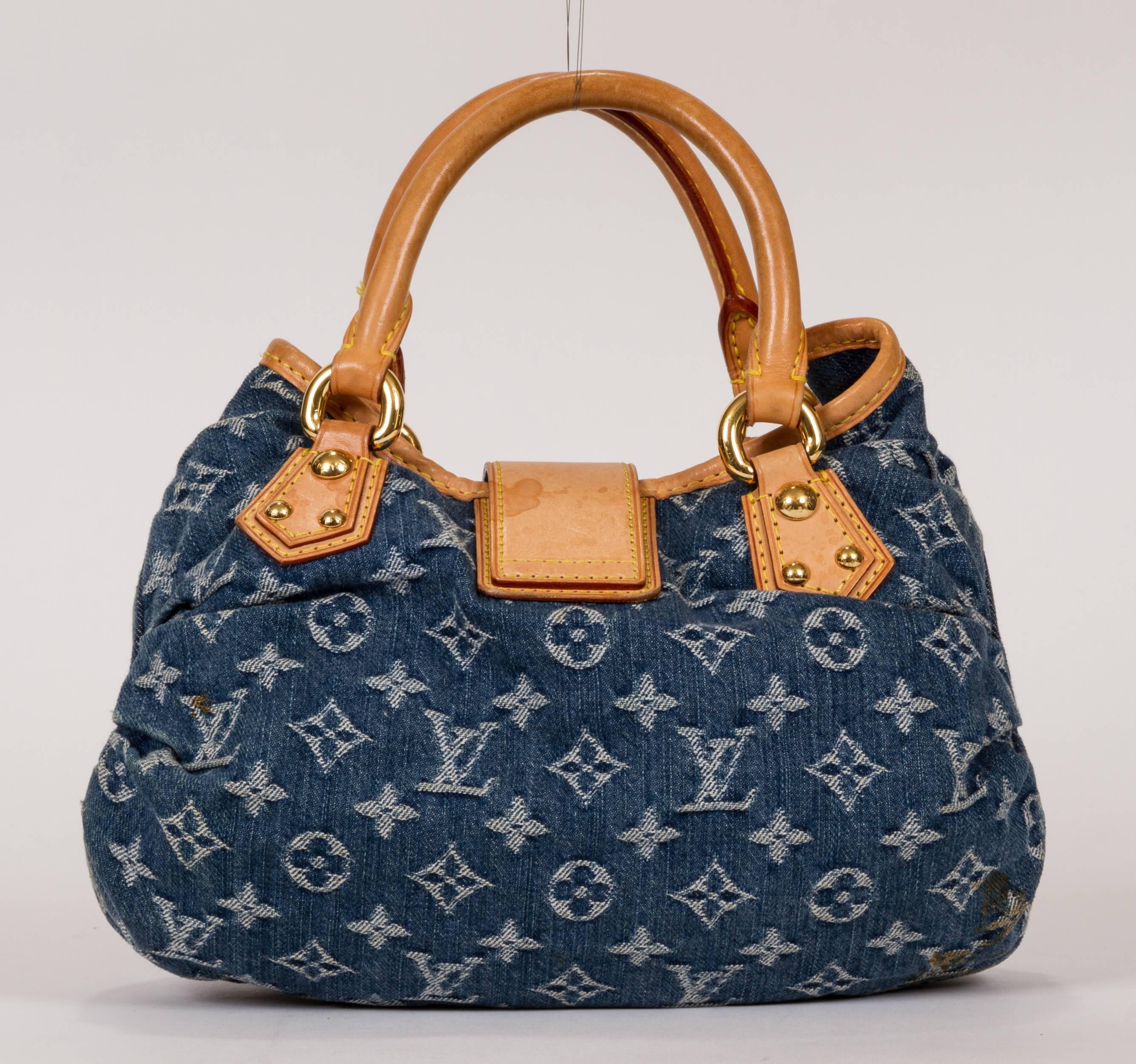 Louis Vuitton blue denim monogram bag. Top strap closure with push lock snap buckle. Stone washed denim with monogram signature logo. Small dark stain on the bottom shown in photo attached. Handles and trim are cowhide leather. Leather shows some