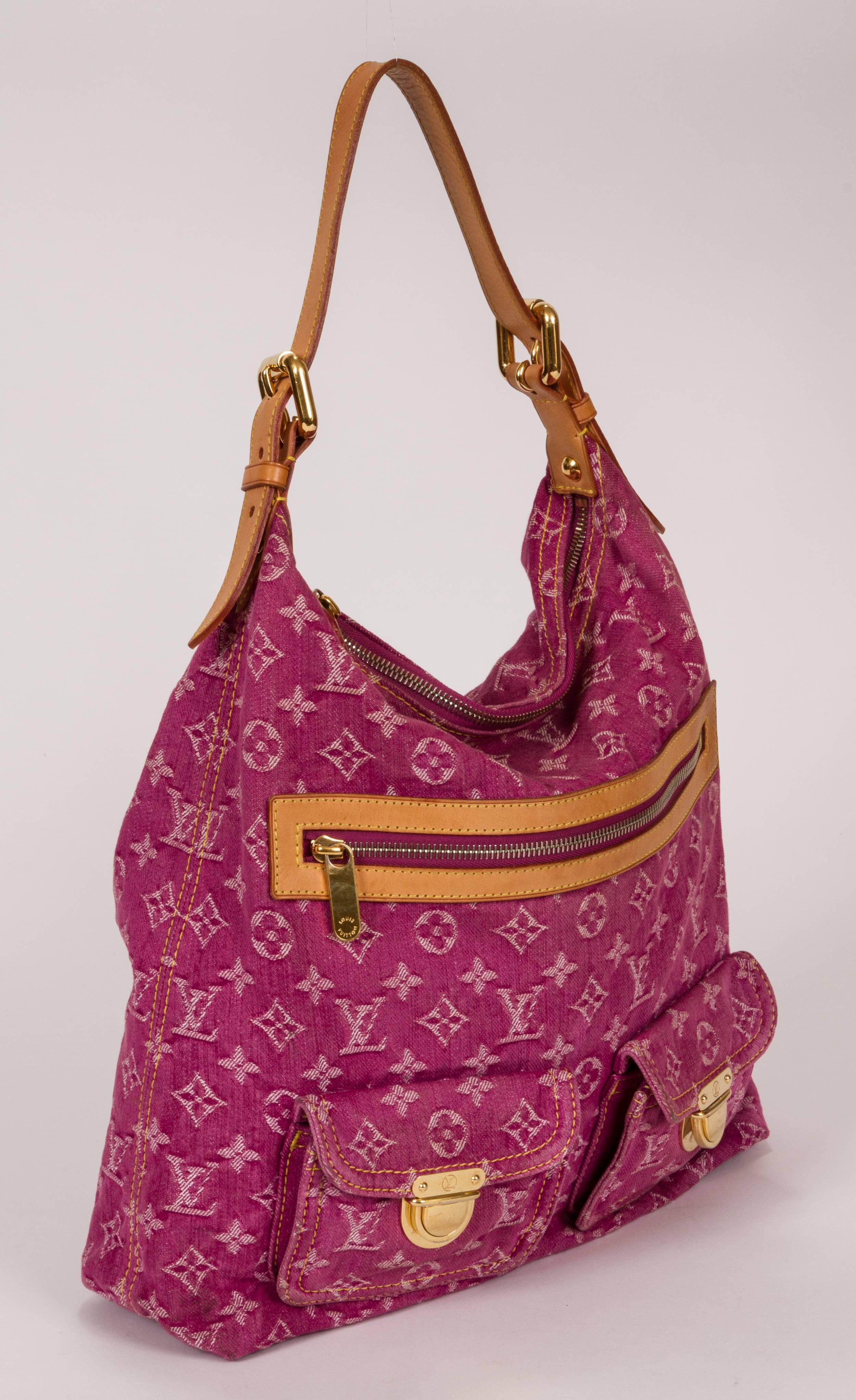Louis Vuitton large monogram denim shoulder bag. Two gusseted push lock pockets and one zipped outside pocket. Item is in excellent condition and shows no signs of wear. Interior in pink alcantara lining is spotless. Leather is light colored and in