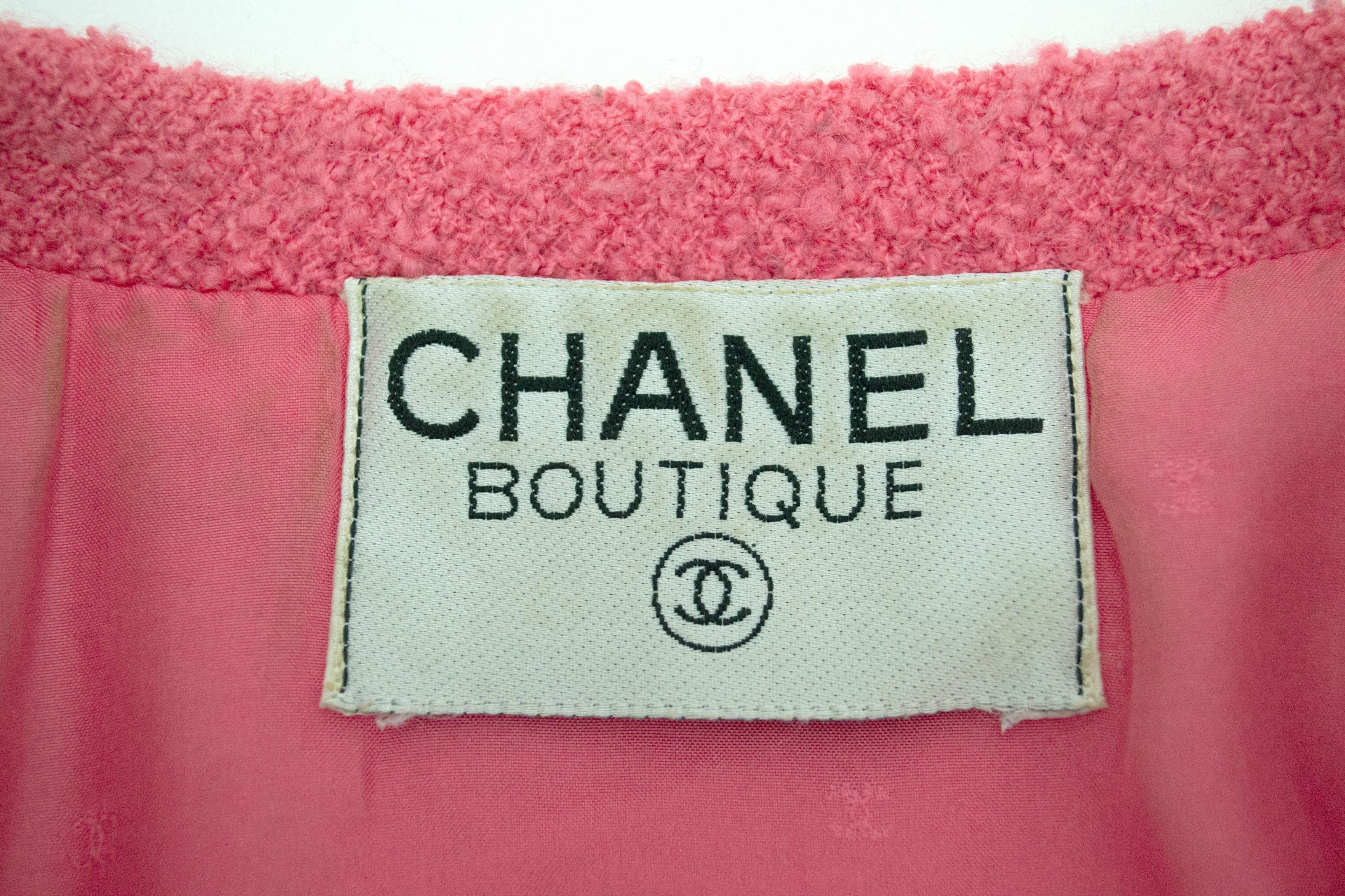 Chanel pink wool boucle double breasted jacket with gold buttons in size 40. Size and fabric content tag is not included. Fully lined in matching pink signature logo silk. Deep front pockets and gold buttons at sleeve cuffs. Darting down the back.