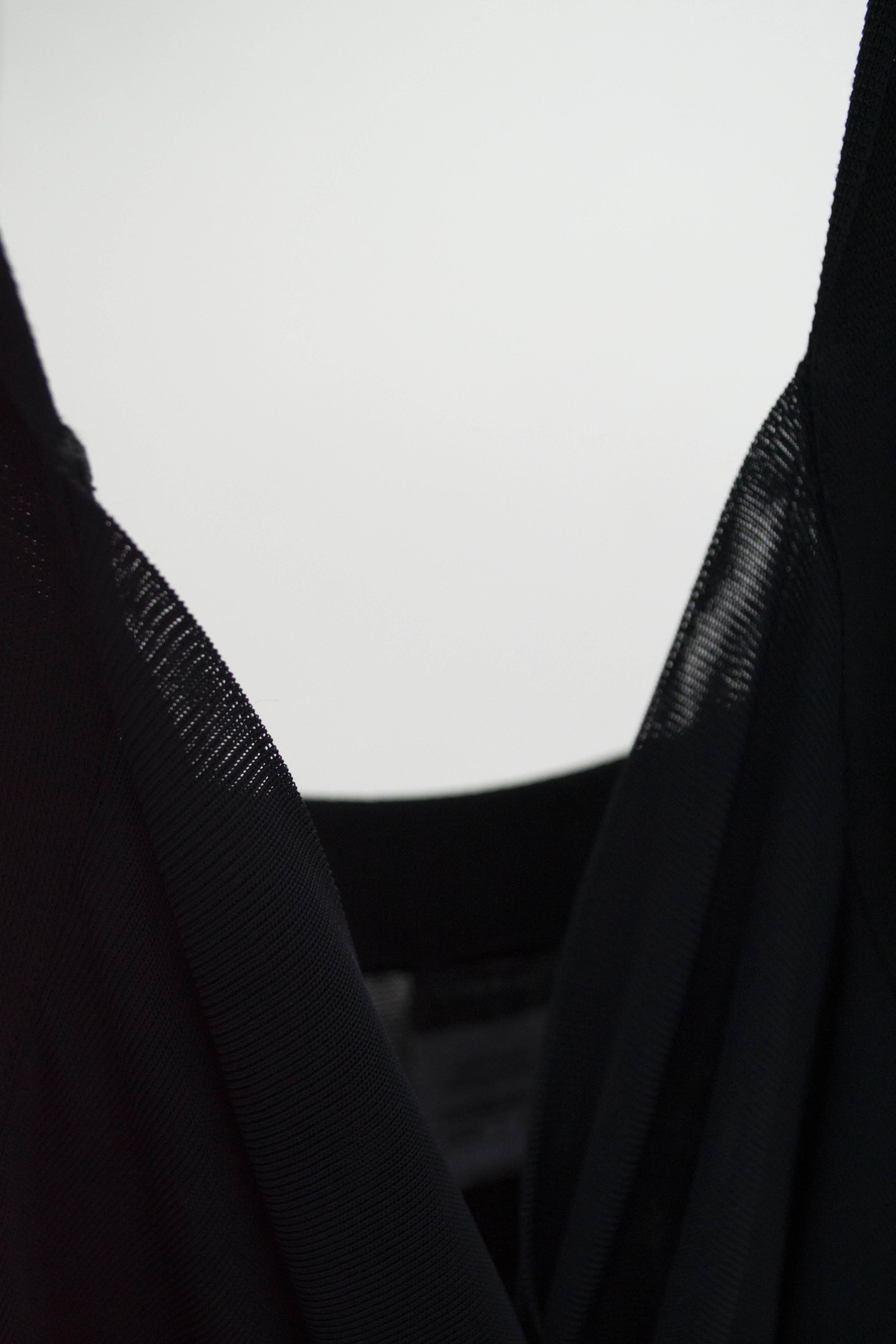 Robe de cocktail Chanel noire en rayonne et élasthanne, taille 42. Détaillée avec des volants en cascade sur le devant et une plaque Chanel en métal au dos. Pas de doublure. Très bon état avec une usure minimale. 