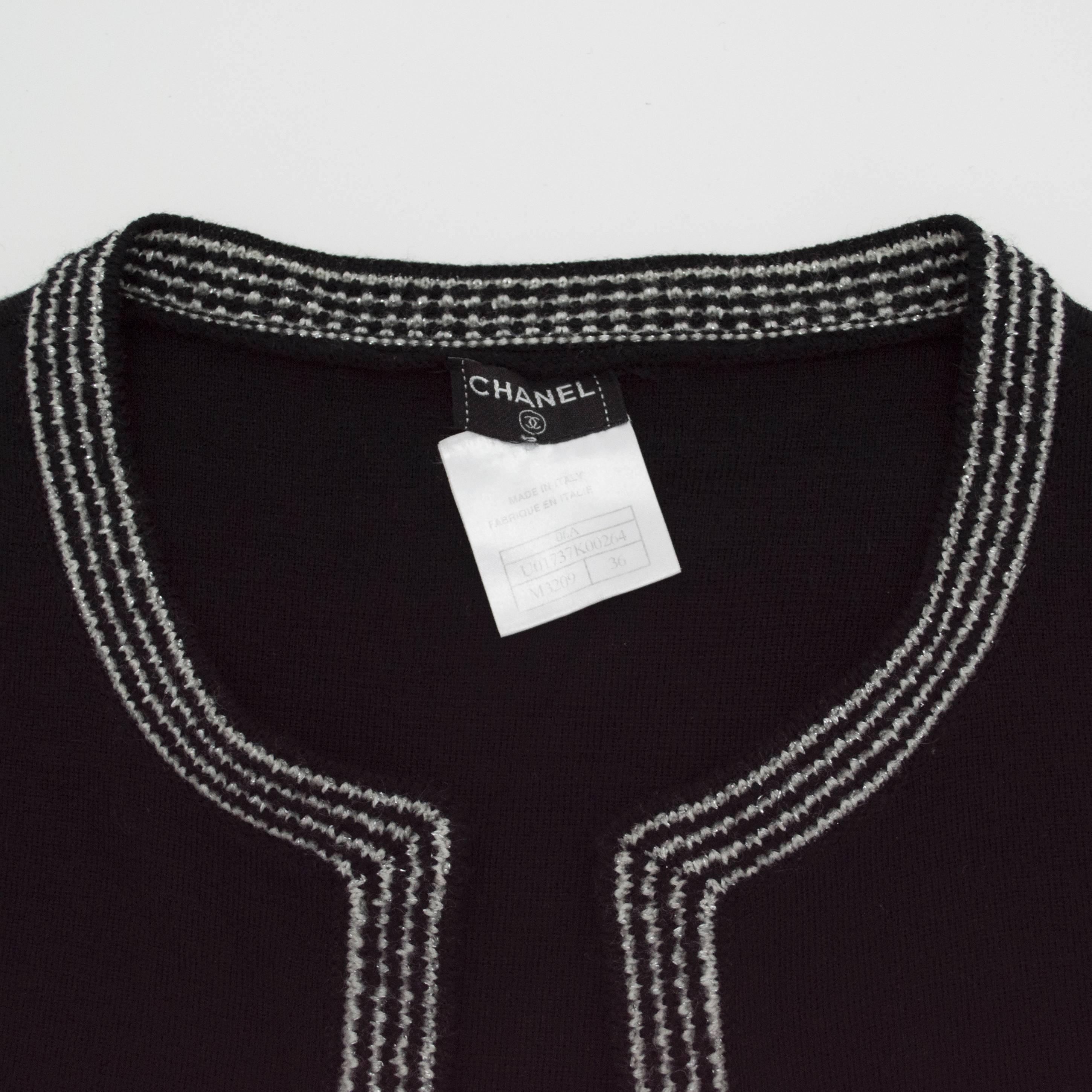 Chanel 2 pc black metallic trimmed short sleeve shell with matching sleeveless vest both in size 36. Soft lighter weight wool with rayon, poly blend. Short Sleeve sweater includes a Chanel name plated rhodium metal button on the bust. From the 2006