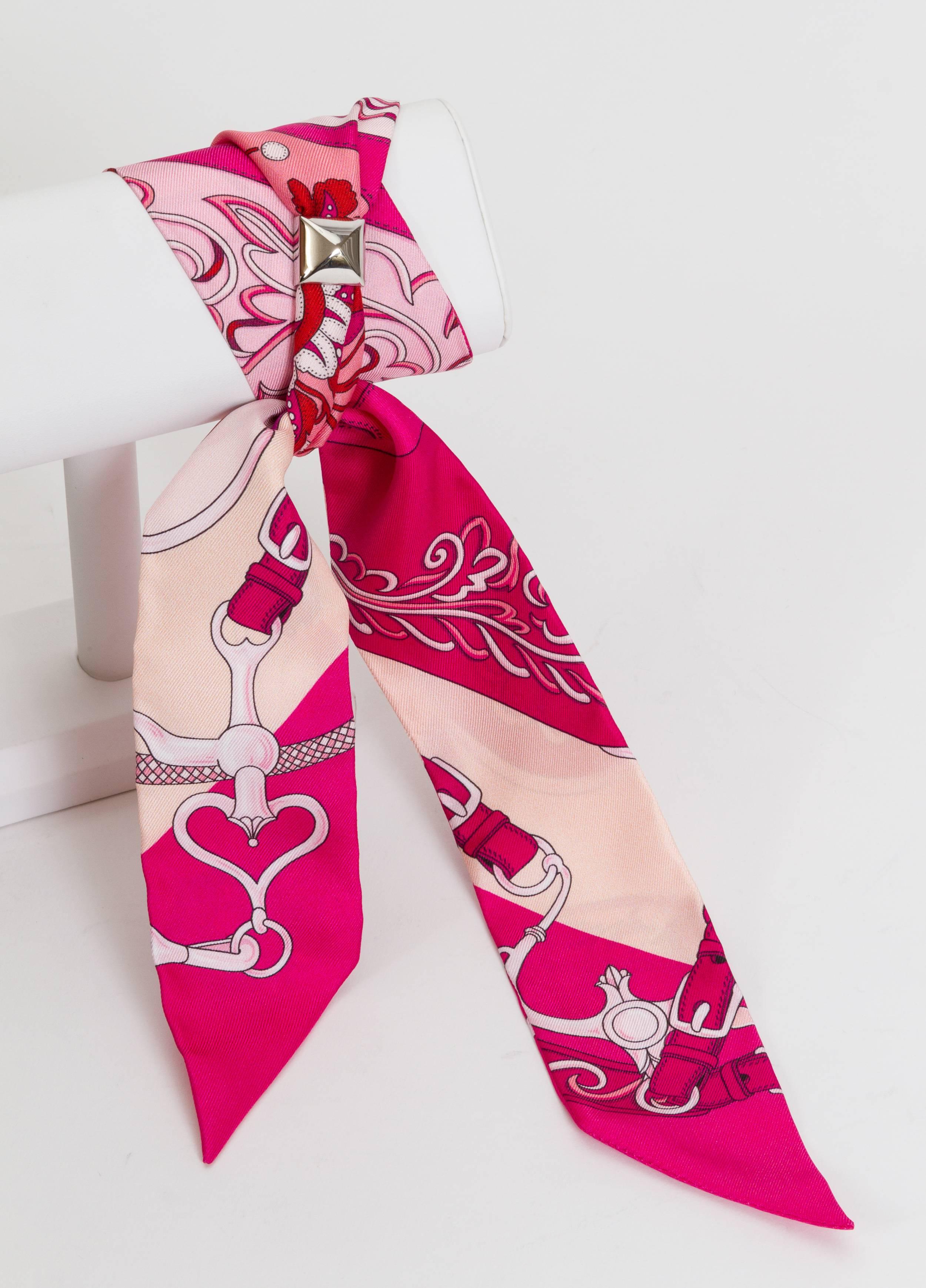 Hermès 100% silk Twilly hot pink flower design with palladium medor metal slide. Can be worn as a bracelet or a scarf. Comes with original box and ribbon.