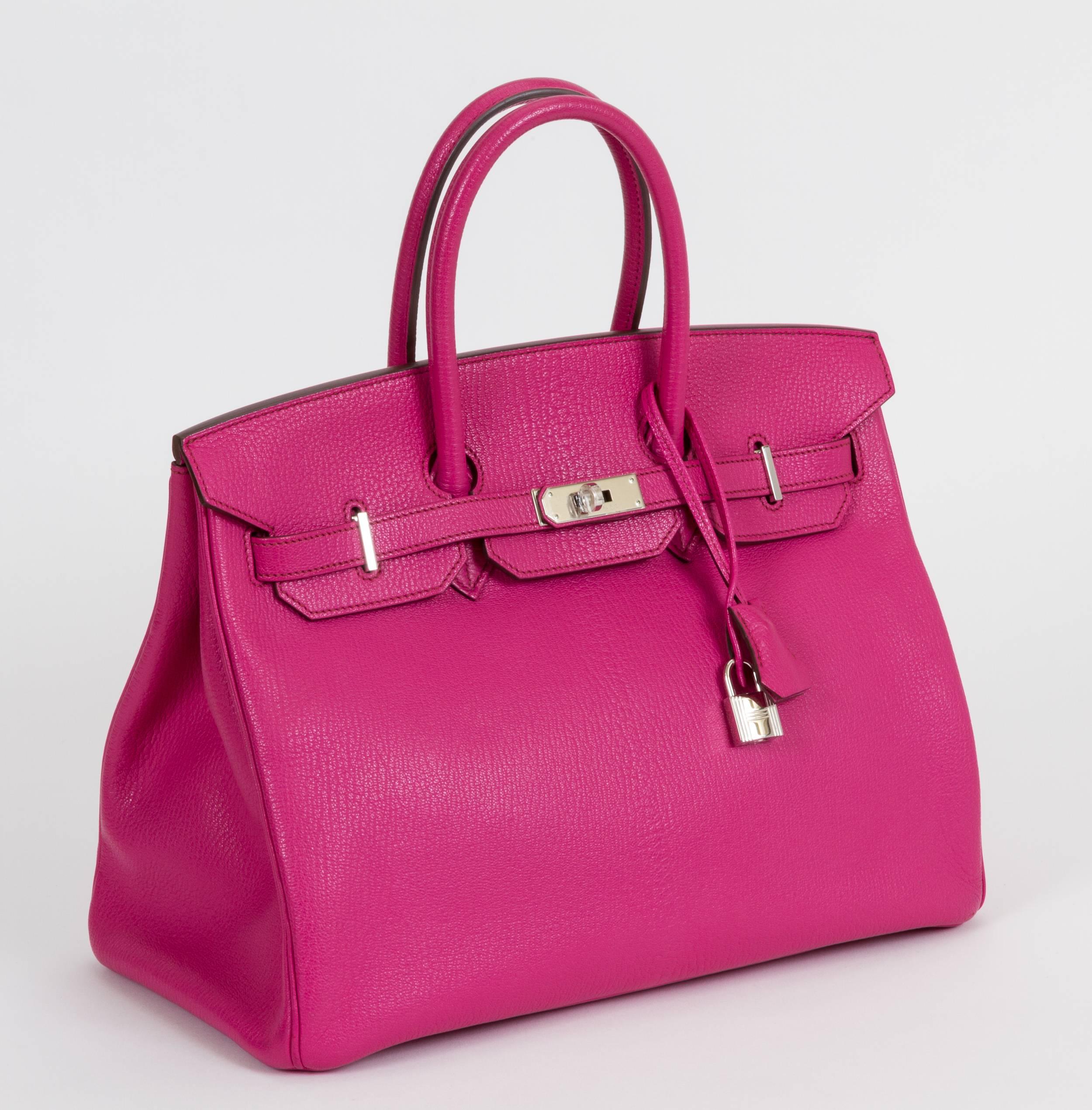 Hermès 35cm Birkin bag in Rose Shocking goat skin and palladium hardware. Partial plastic on hardware, has been carried. Includes clochette, tirette, lock, keys, rain jacket, dust bag, and gift bag. Date stamp M in a square for 2009.