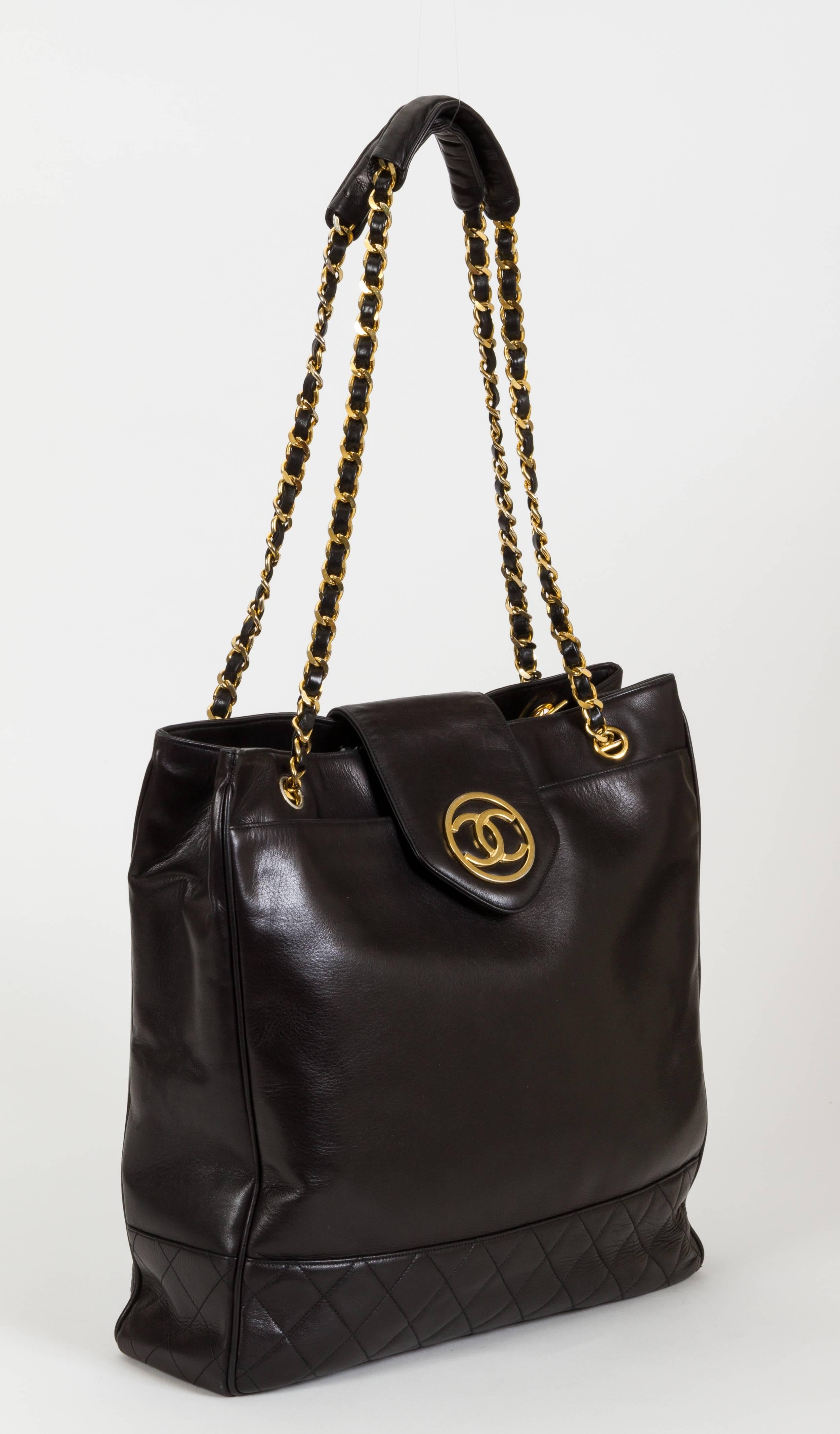 Chanel large black leather day tote with goldtone hardware. Front pocket, zipped interior pocket. Shoulder drop, 13