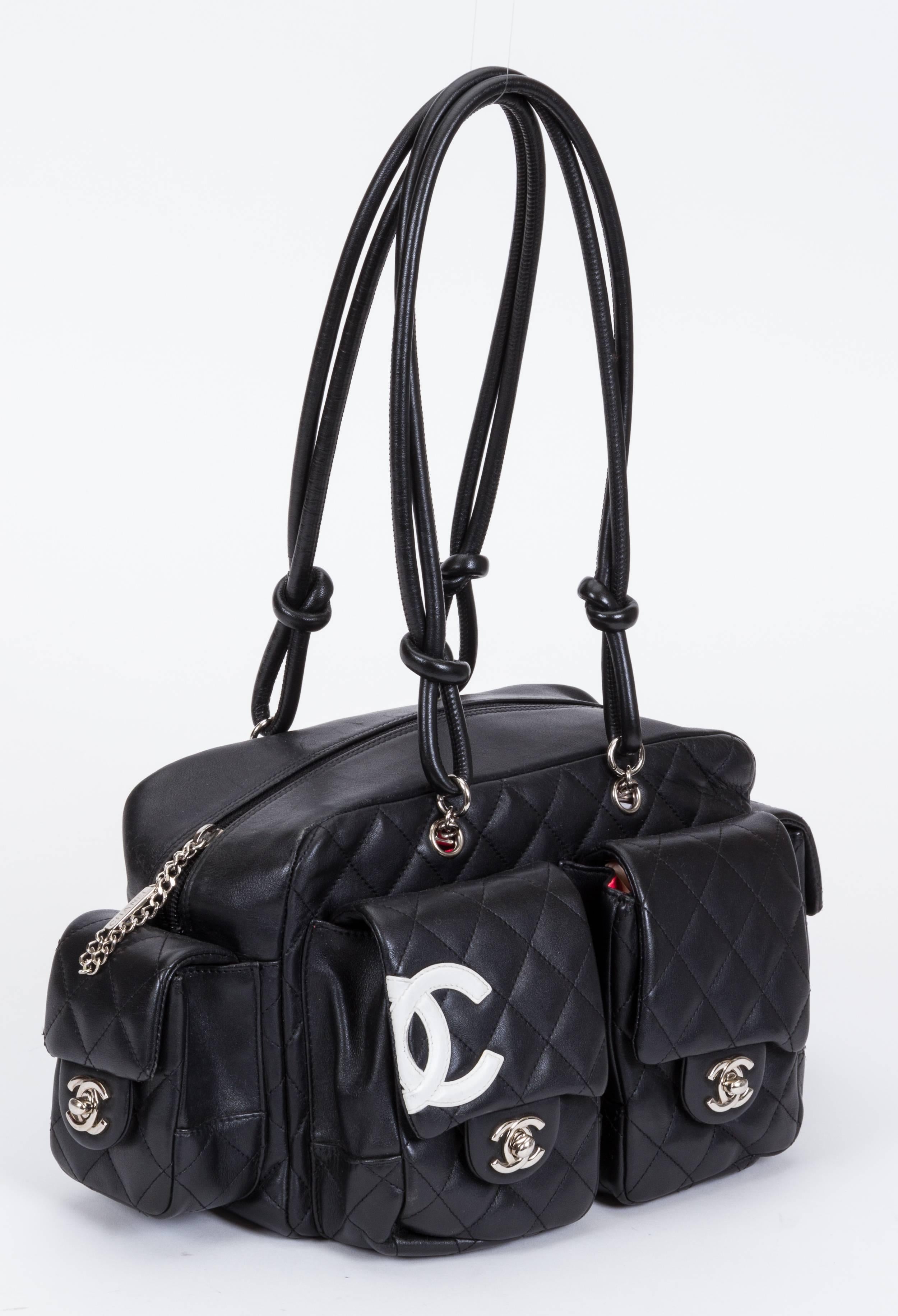 Chanel black lambskin reporter bag with white logo . Collection 2005/2006. Shoulder drop, 10"L. Comes with hologram and non Chanel dust cover.