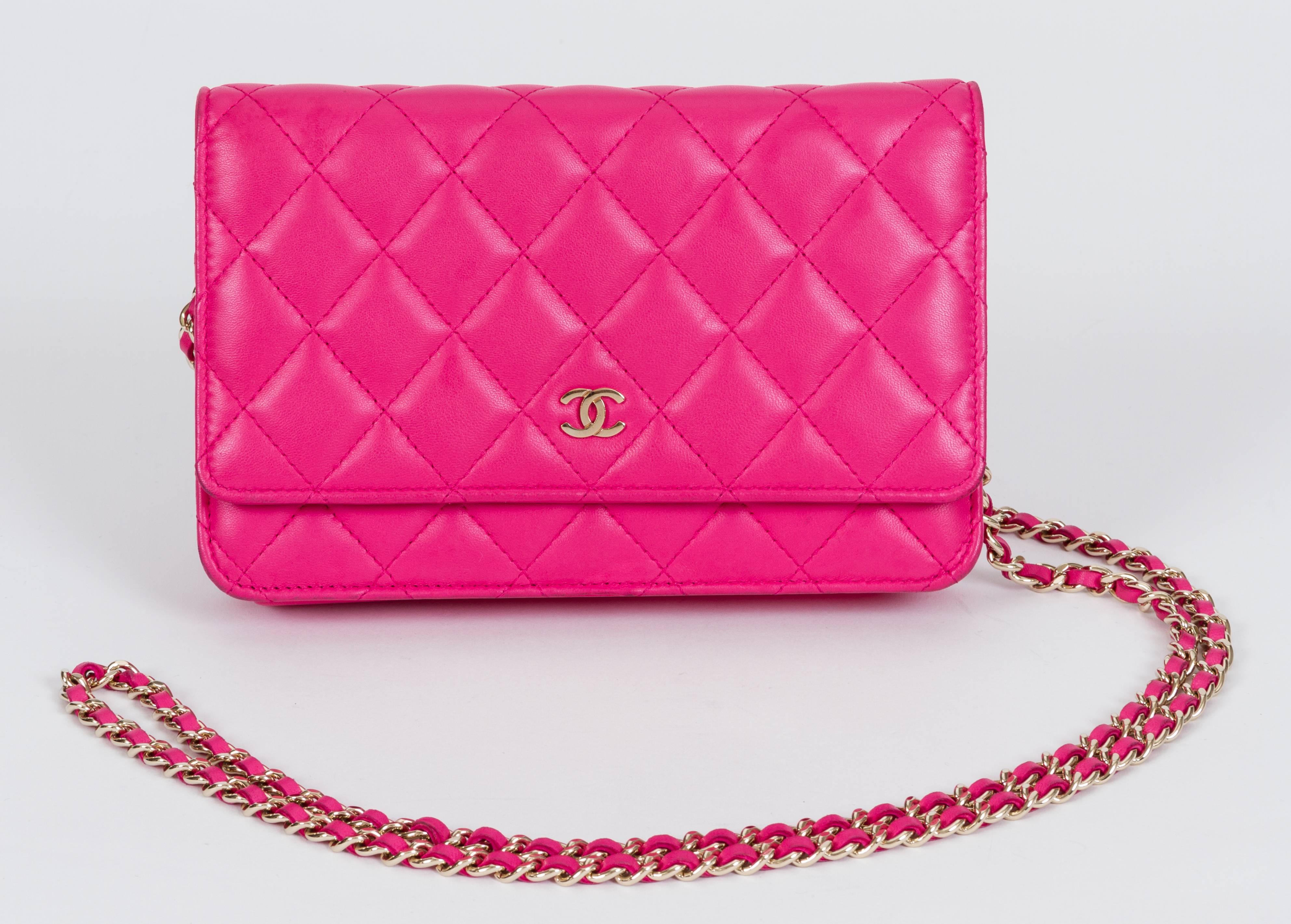 Chanel fuchsia lambskin quilted wallet on a chain with gold tone hardware. Can be worn as a clutch or as a cross body. Mint interior and minor wear on edges as shown in photos. Measurements 7.5
