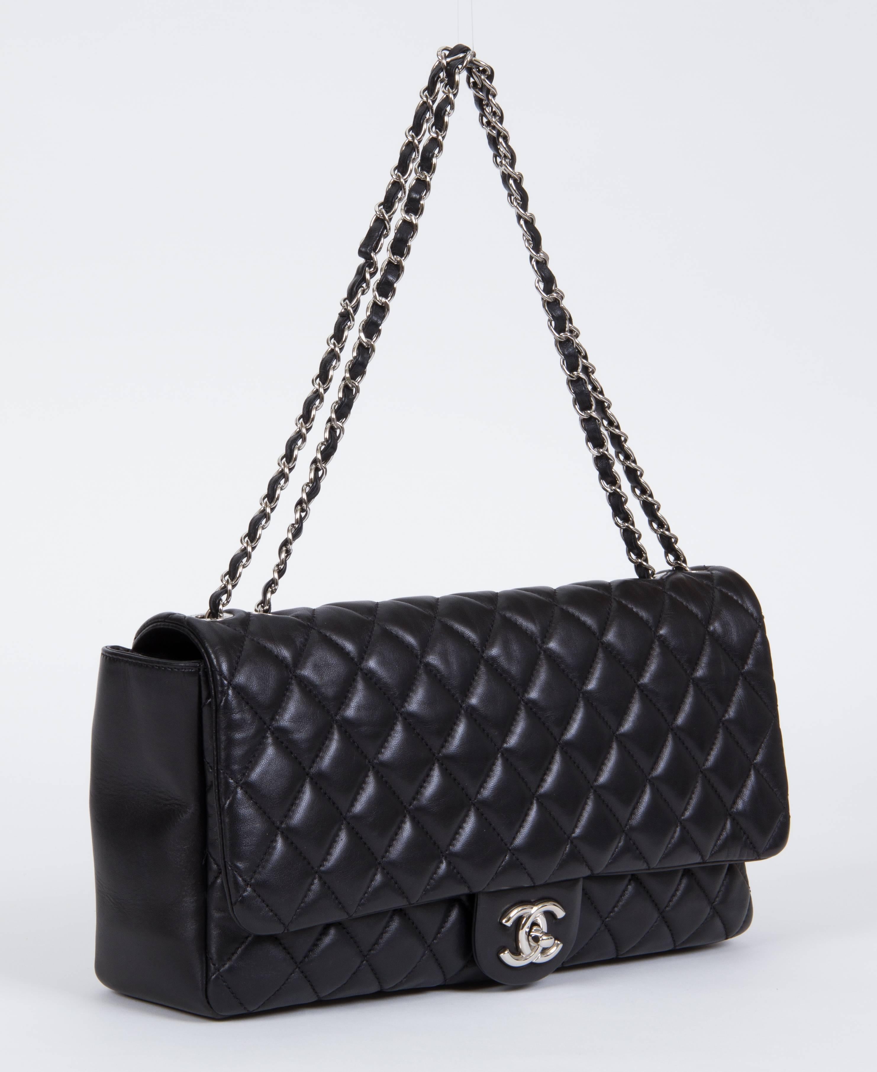 Chanel limited edition black lambskin quilted jumbo flap with silver tone hardware. Special edition with retractable rain jacket. Measurements: 13