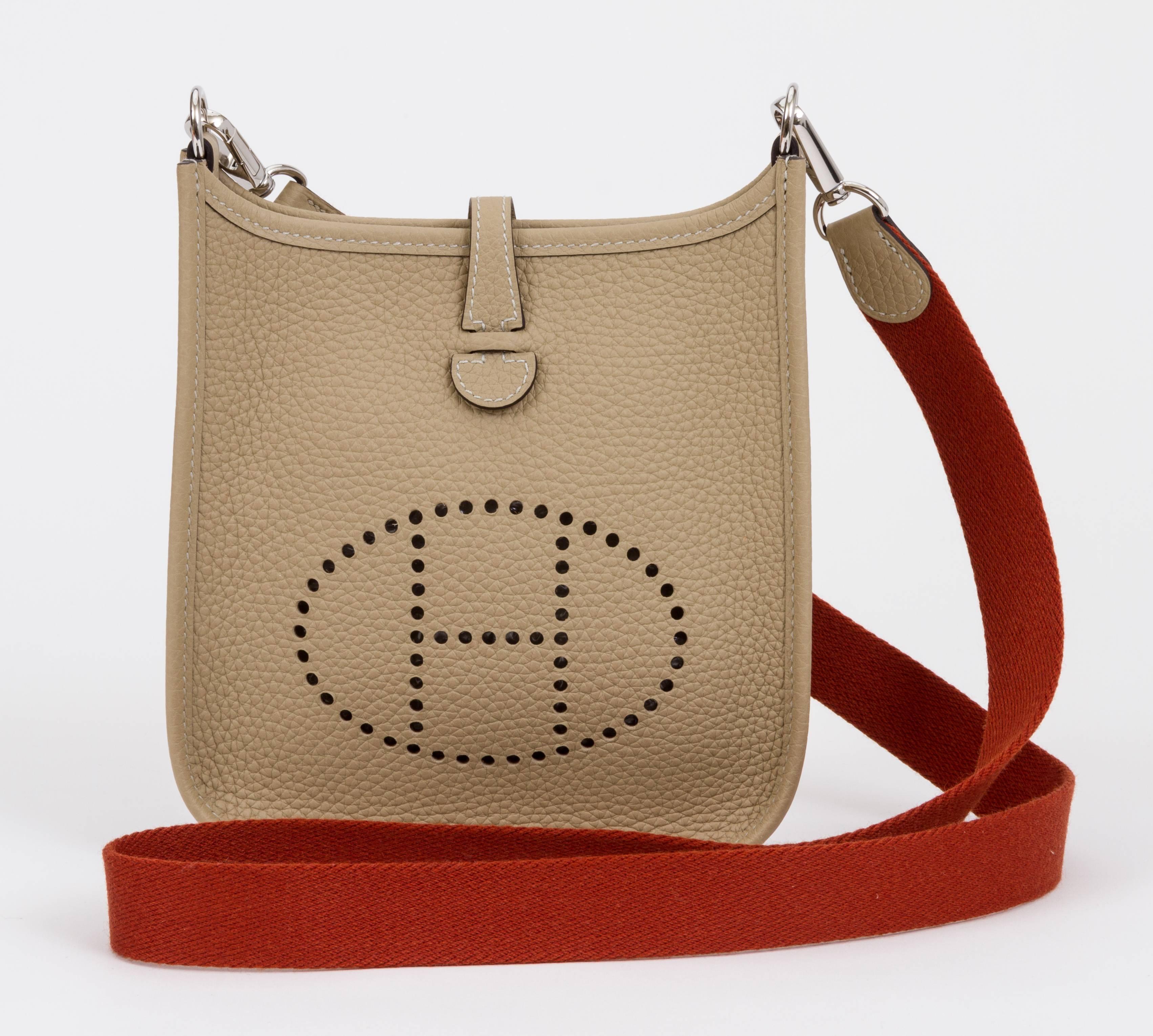 Hermès mini Evelyne shoulder bag in trench clemence leather with palladium hardware. Contrast strap in rust color and trench leather. Never used. Dated 