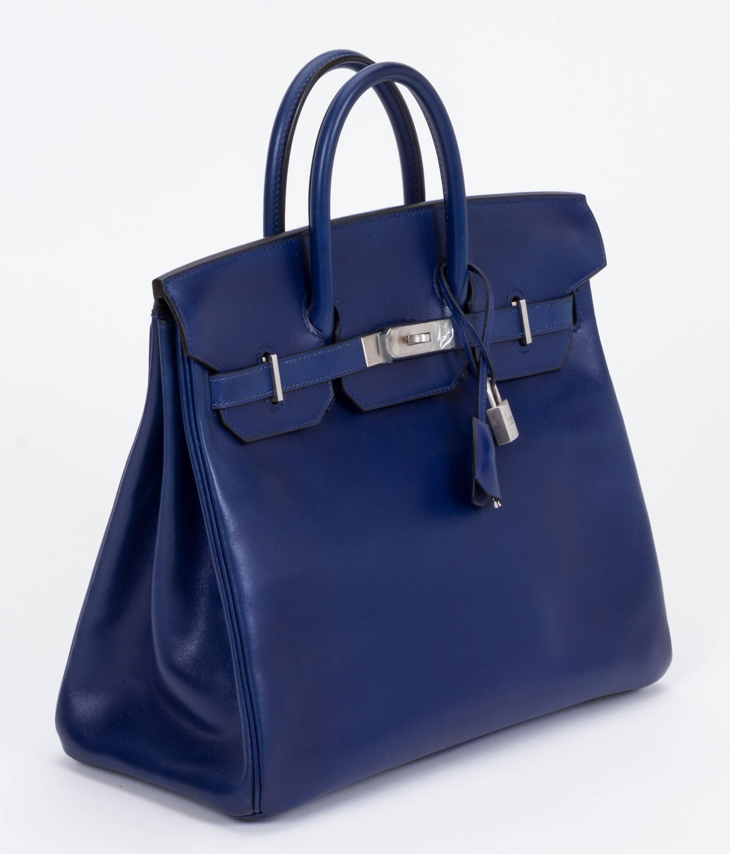 Hermès 32cm Birkin HAC bag. Box calf blue sapphire leather with brushed palladium hardware. Date stamp D for 2000. Handle drop, 3.5"L. Partial plastic still on hardware. Comes with original rain jacket and box. No duster
