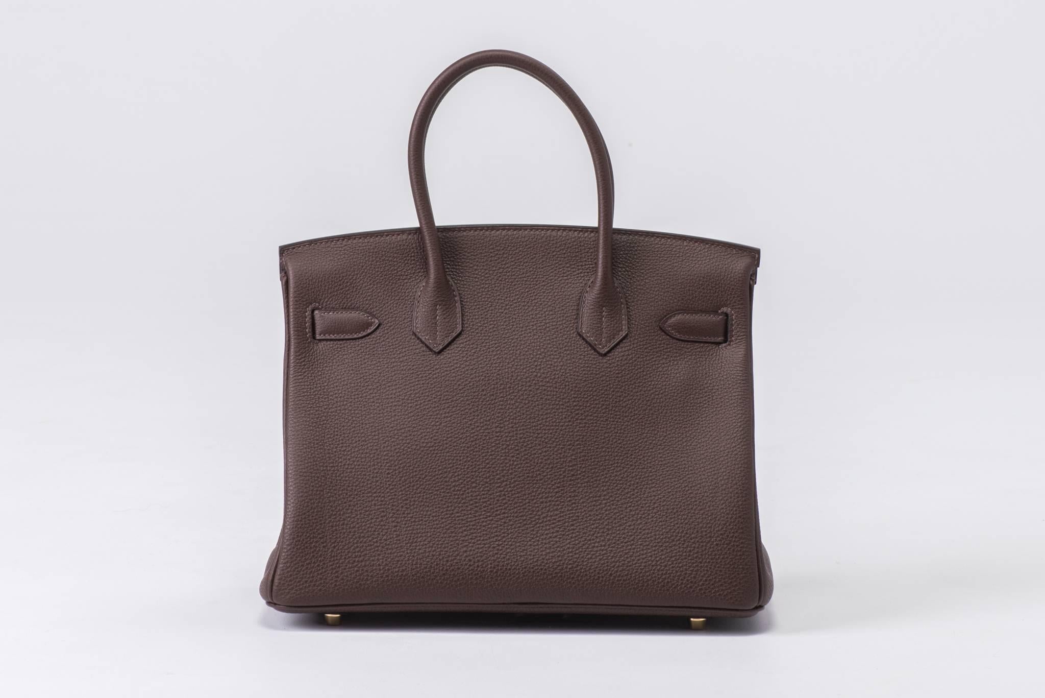 Hermes brand new in box, never carried, Birkin 30 cm cocoa brown togo leather and gold tone hardware. Handle drop 4". Dated T for 2015. Comes with full set: clochette, tirette, lock, keys, rain jacket, dust cover, box and ribbon.
