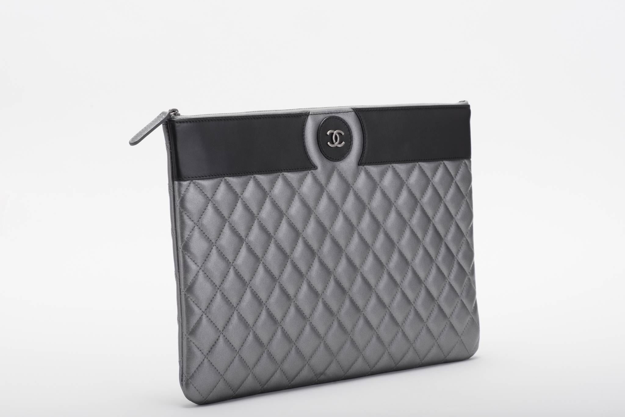 Chanel brand new in box timeless black and pewter quilted clutch. Signature center CC logo. Comes with hologram, ID card, booklet, box and ribbon.