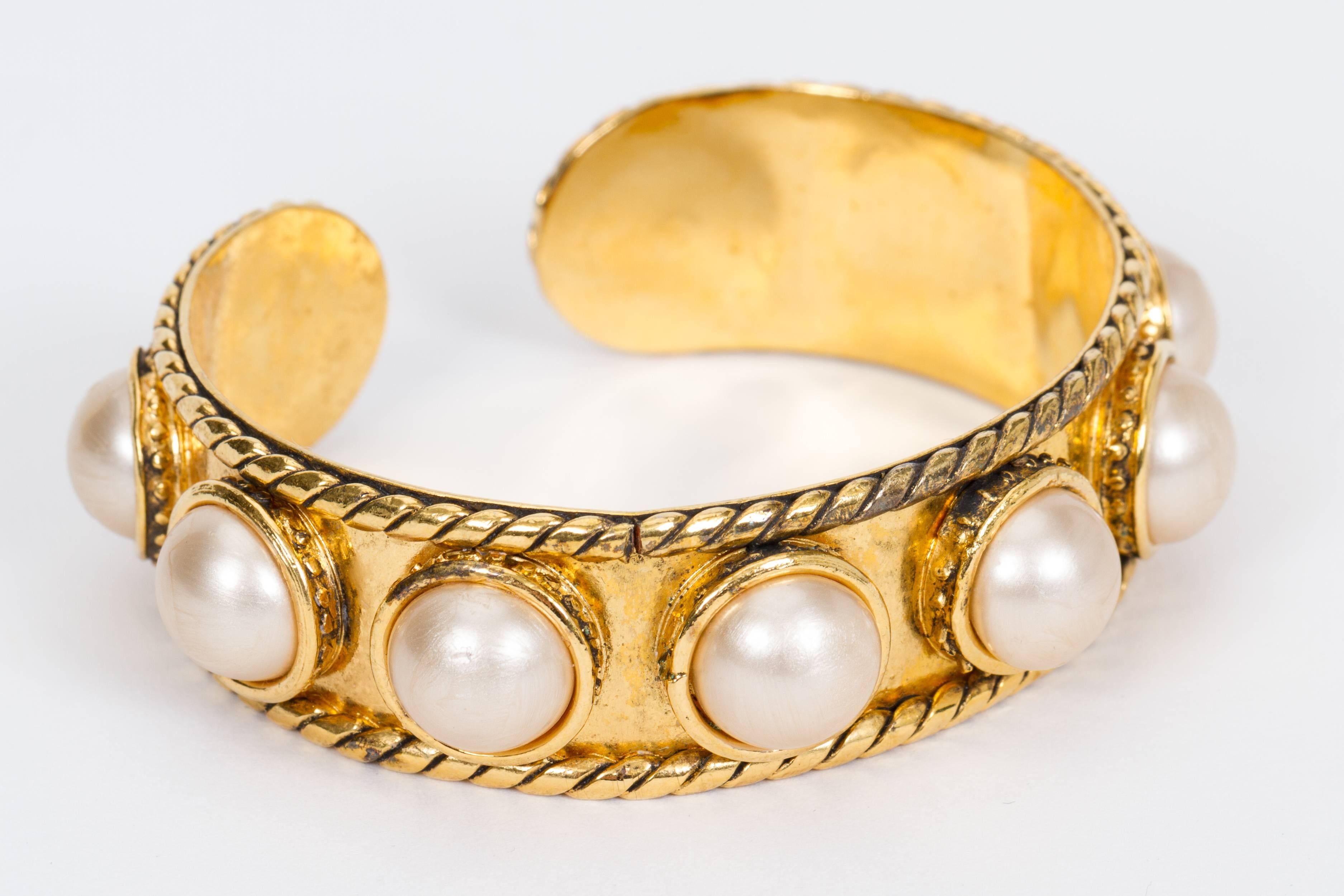 Chanel late 80's shiny gold and faux pearls cuff bracelet. Cuff opening 7/8. Fits a small to medium arm. Comes with original box.
