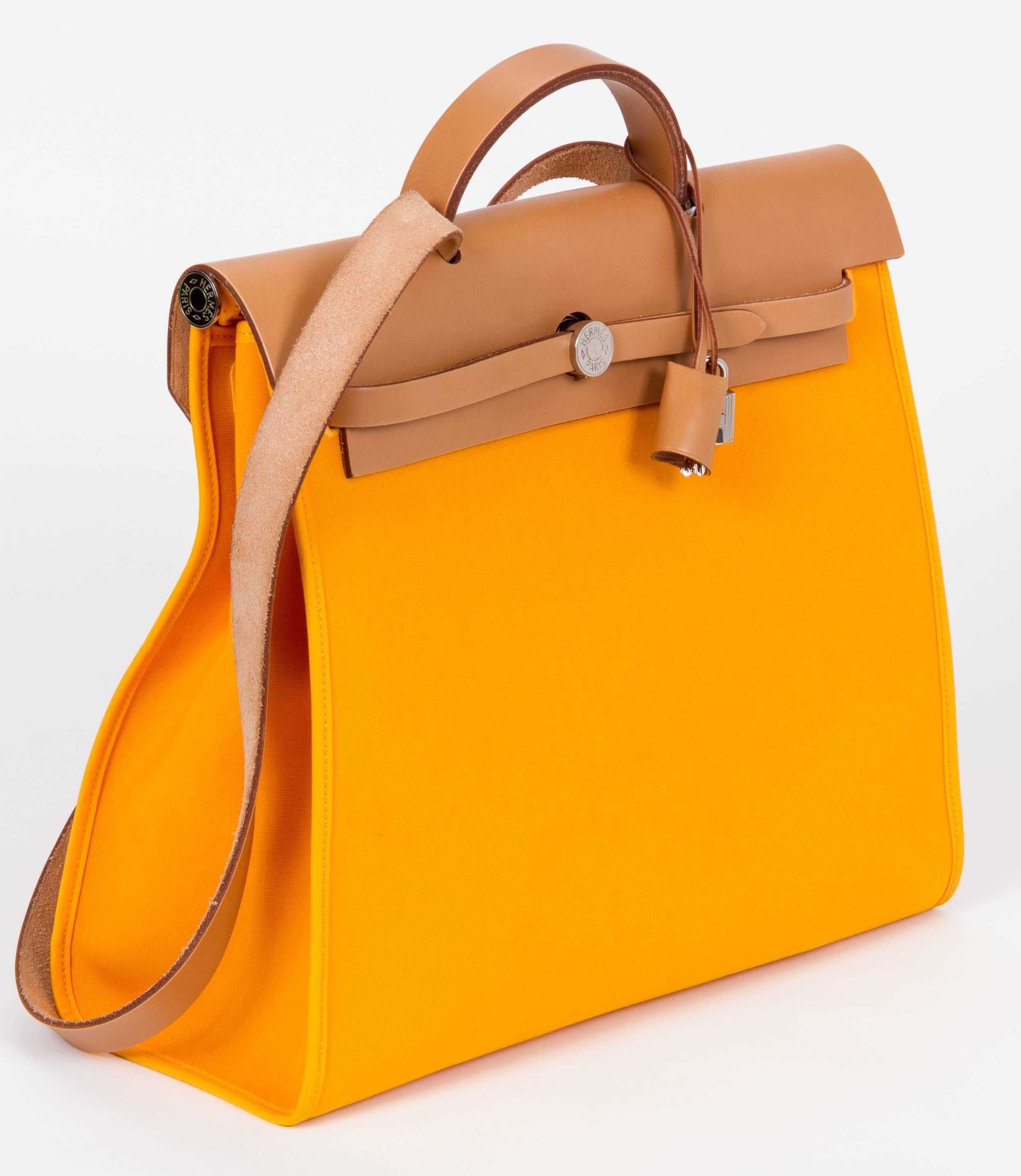 Hermes herbag in large size. Yellow exterior canvas and orange interior with natural cowhide leather strap and top. Shoulder drop 18