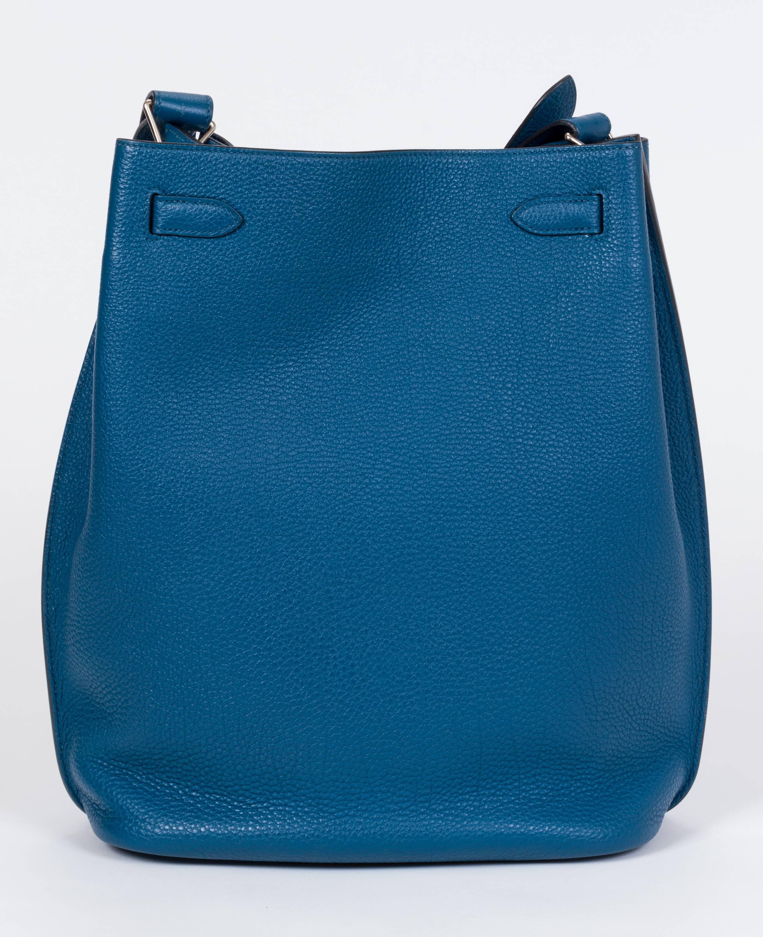 Hermès So Kelly 26 in blue Izmir clemence leather with palladium-plated hardware, single adjustable shoulder strap, tonal Chevre leather lining, dual pockets at interior walls; one with zip closure and turn-lock closure at top. Shoulder drop 10