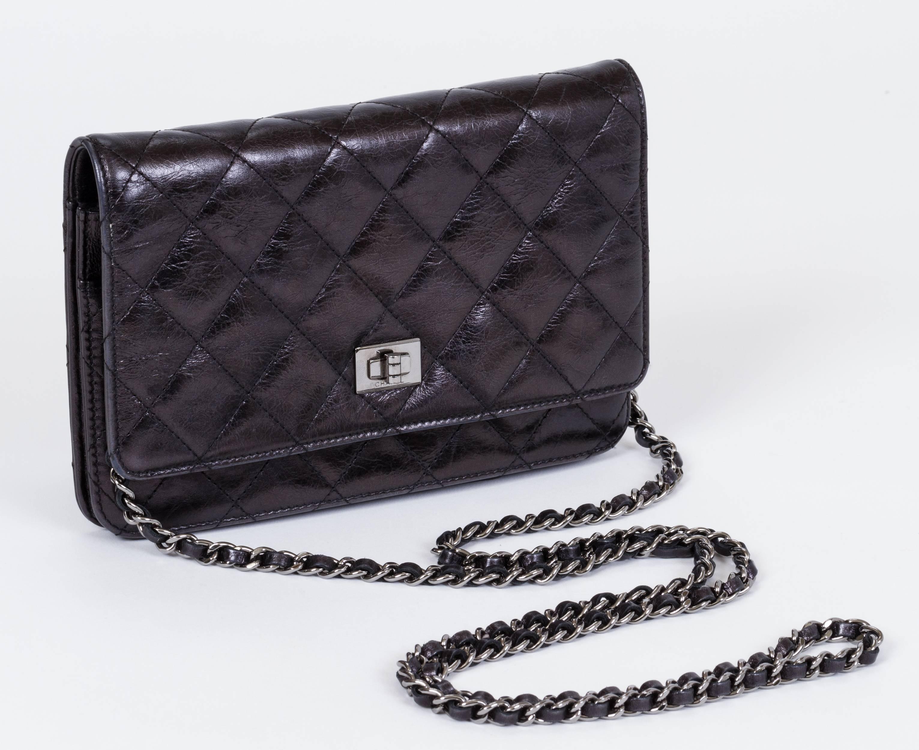 Chanel black distressed reissue quilted wallet on a chain with gunmetal hardware. Can be worn as a clutch or as a cross body. Very good condition. Measurements 7.5