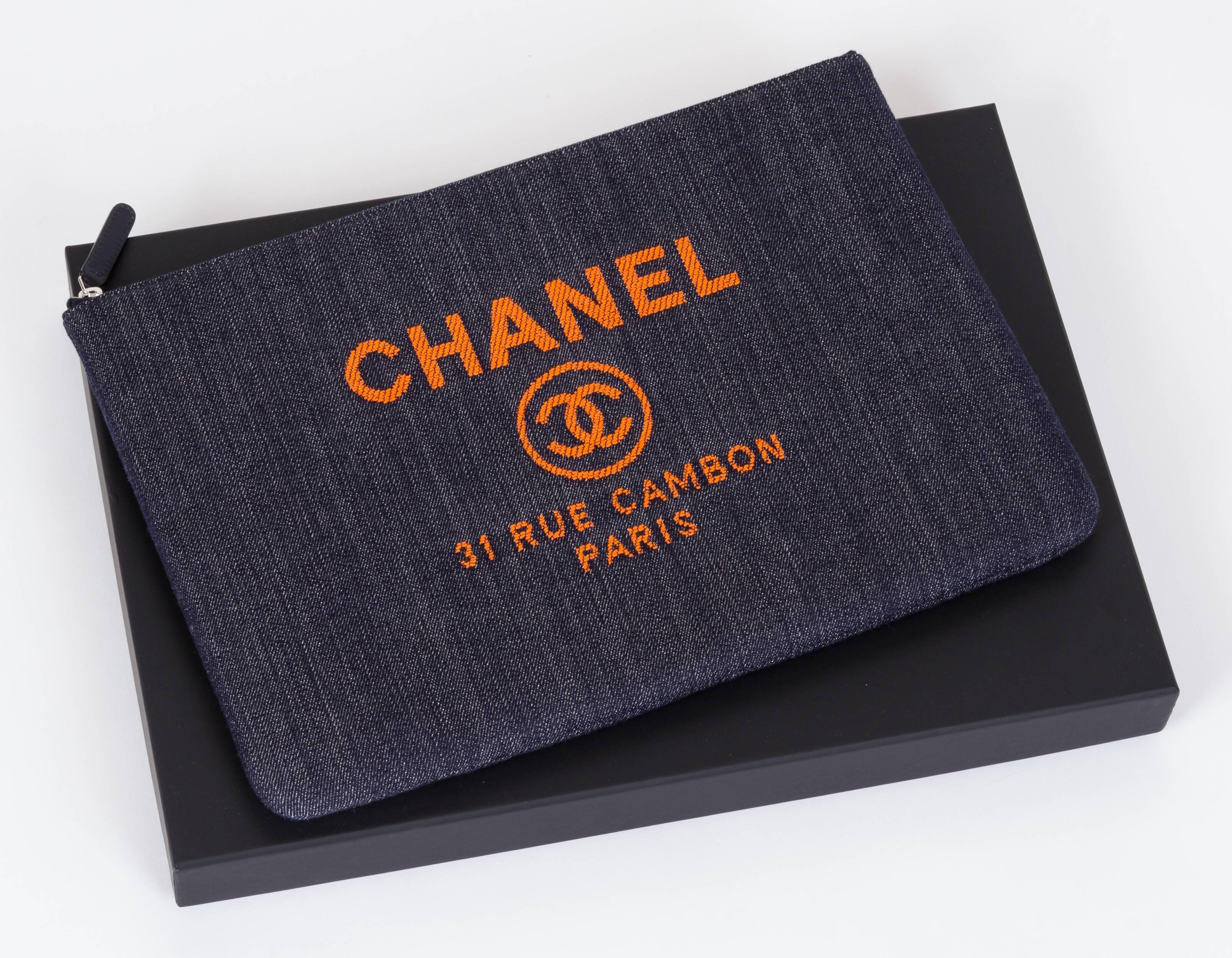 Chanel large denim clutch from Spring 2017 collection with orange signature logo, and Chanel address. New in box with hologram, ID card, booklet, dust cover, box and ribbon.