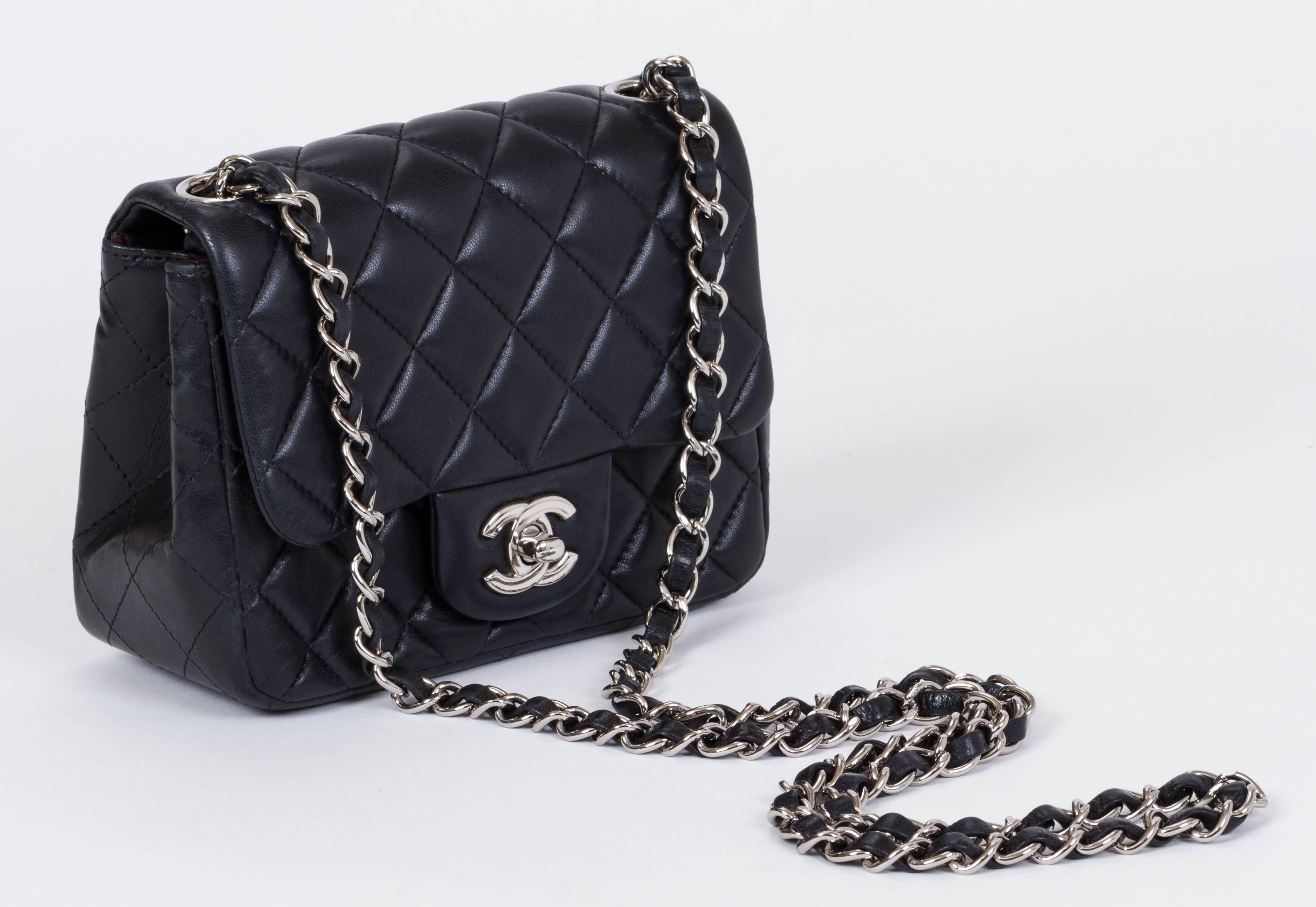 Chanel black lambskin quilted cross body mini flap bag. One exterior back pocket and one interior zipped compartment. Shoulder drop 21