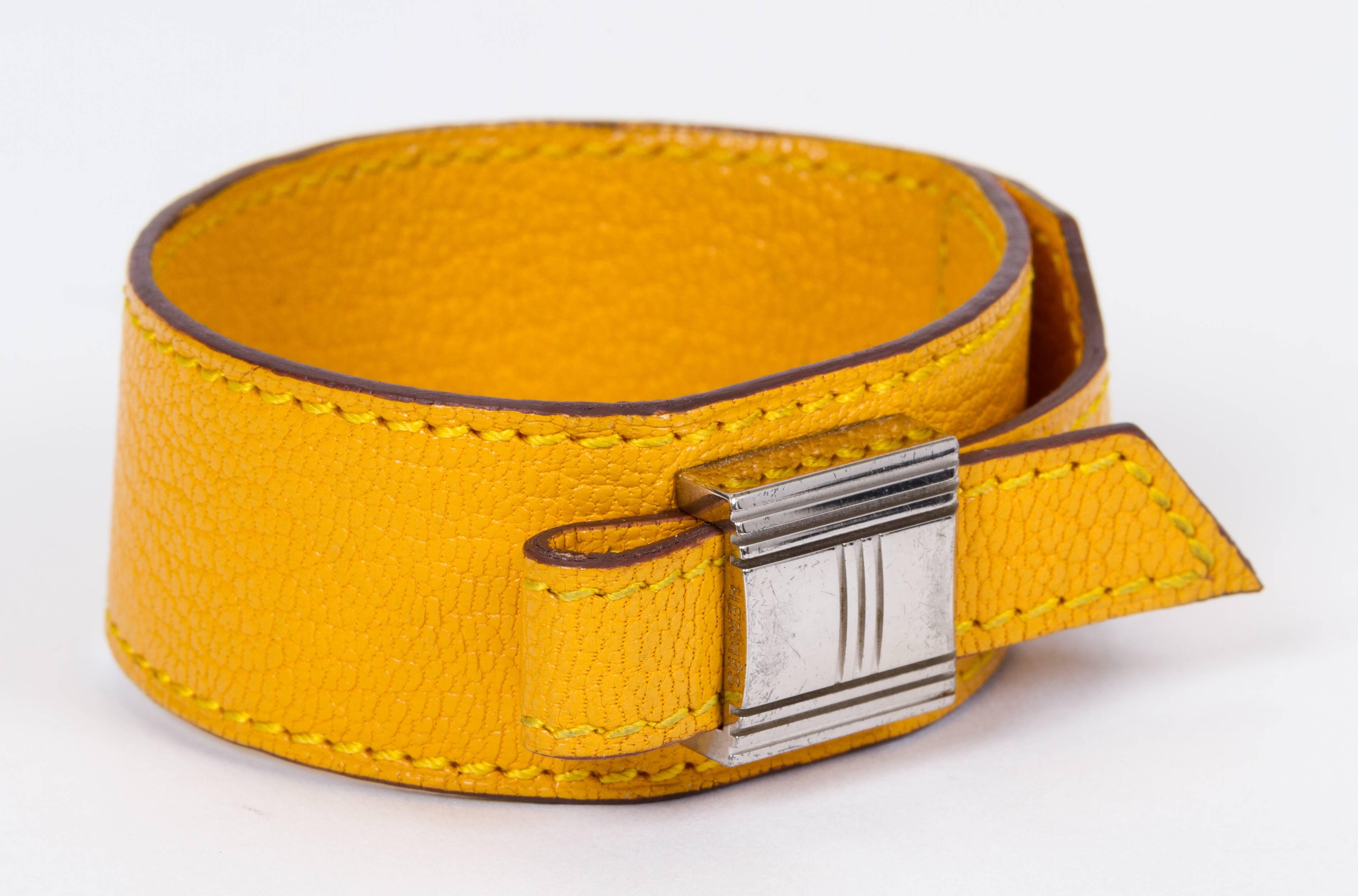 Vintage Hermès yellow leather bracelet palladium hardware slide. Fits any size. Gold hardware in excellent condition. Date stamp F for 2002. Comes with original box. Minor wear on the interior.