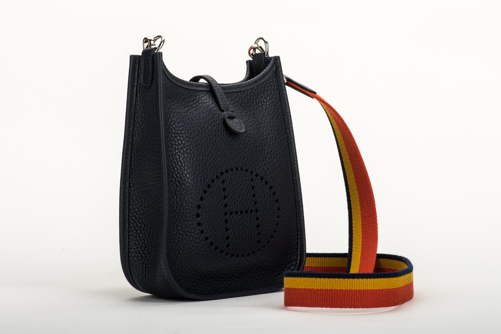 Hermès mini Evelyne shoulder bag in blue indigo Clemence leather with palladium hardware. Multicolor strap. Never used. Dated 