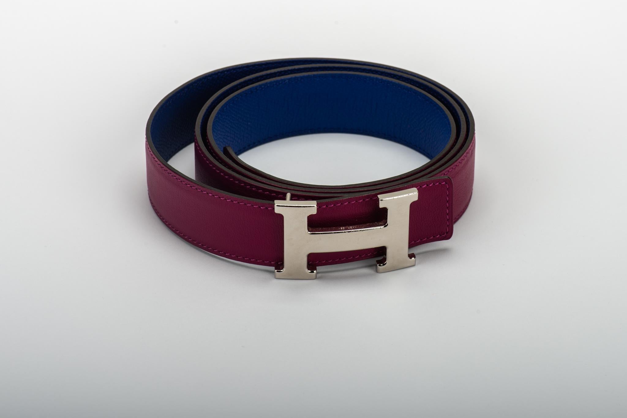 Hermès unisex reversible leather H belt. Ruby Epsom leather, purple Swift leather, and smooth palladium belt buckle combination. Size 110 cm. Date stamp R for 2014. Comes with original dust bag. Minor scuffs on leather and metal. Two holes have been