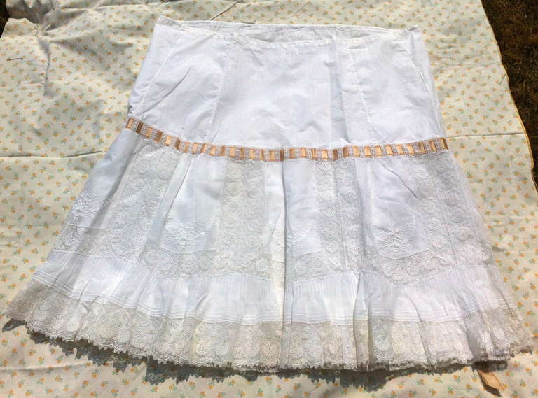 France, circa 1900

Magnificent petticoat of fine linen batiste adorned with a beautiful flounce of lace at the bottom, original golden colored silk ribbon still on.
Beautiful workmanship and very fine work.
Like new condition.
Waist is