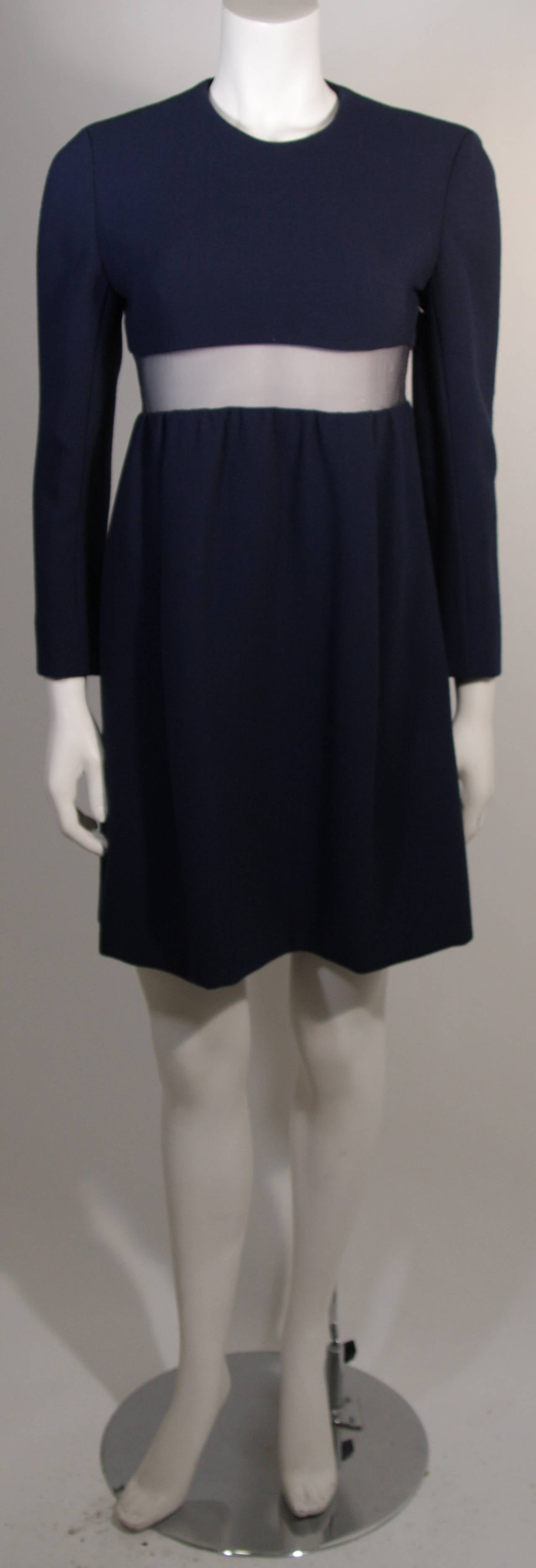 This Galanos dress is composed of a blue wool with long sleeves and features a mesh waist detail. There is a side zipper for ease of access and side pockets. A delightful design. 

Measures (Approximately)
Length: 35.5
