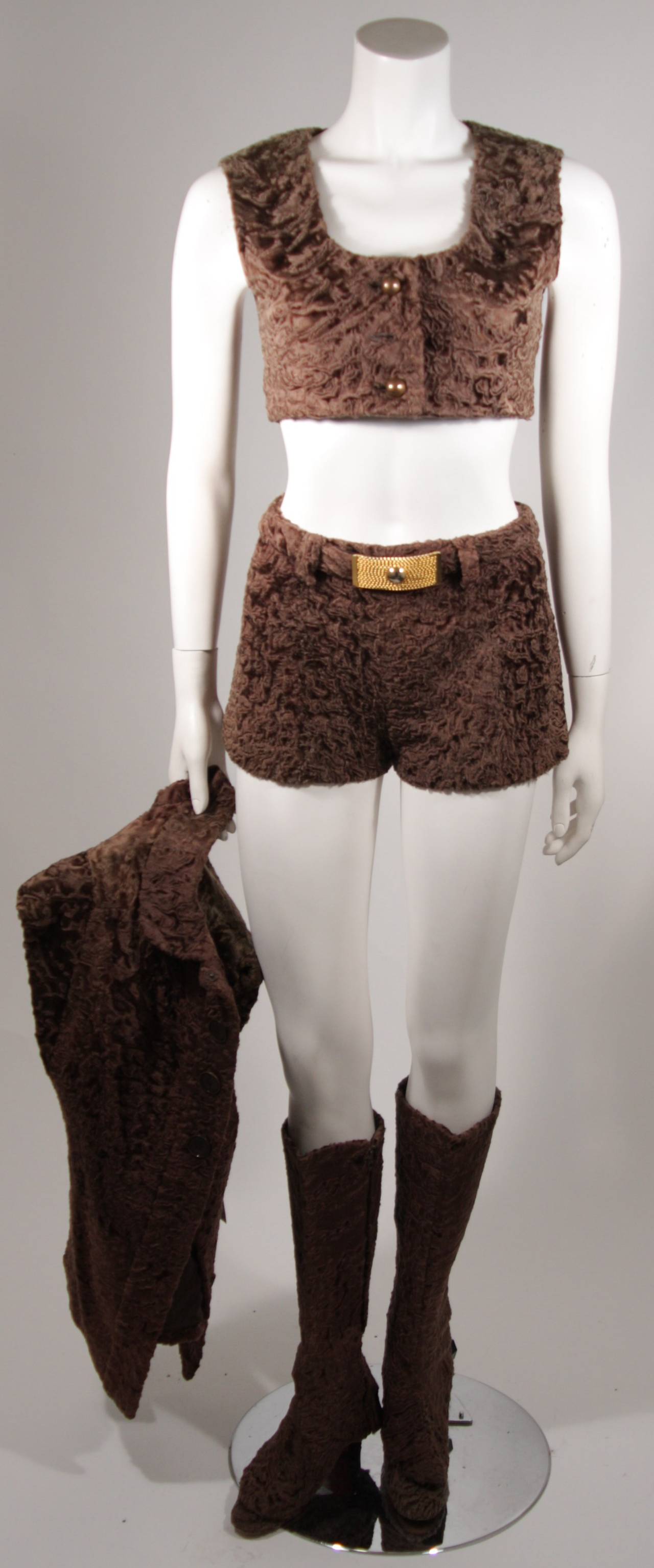This Broadtail chocolate ensemble comes with a jacket, a vest (missing one button), and shorts with a zipper back closure accented with a belt. There are shoes (size unknown) with boot spats. The set is suffering from discoloration (which may