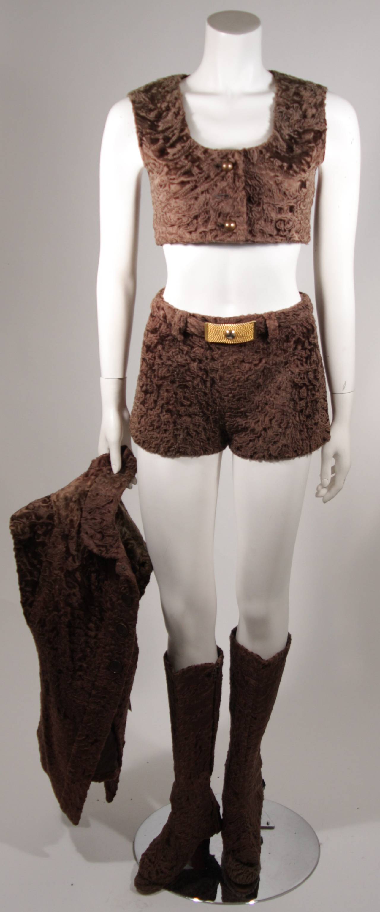 Questo completo di cioccolato Broadtail è composto da una giacca, un gilet (a cui manca un bottone) e pantaloncini con chiusura posteriore a cerniera e cintura. Ci sono scarpe (numero sconosciuto) con ghette per stivali. Il set è affetto da