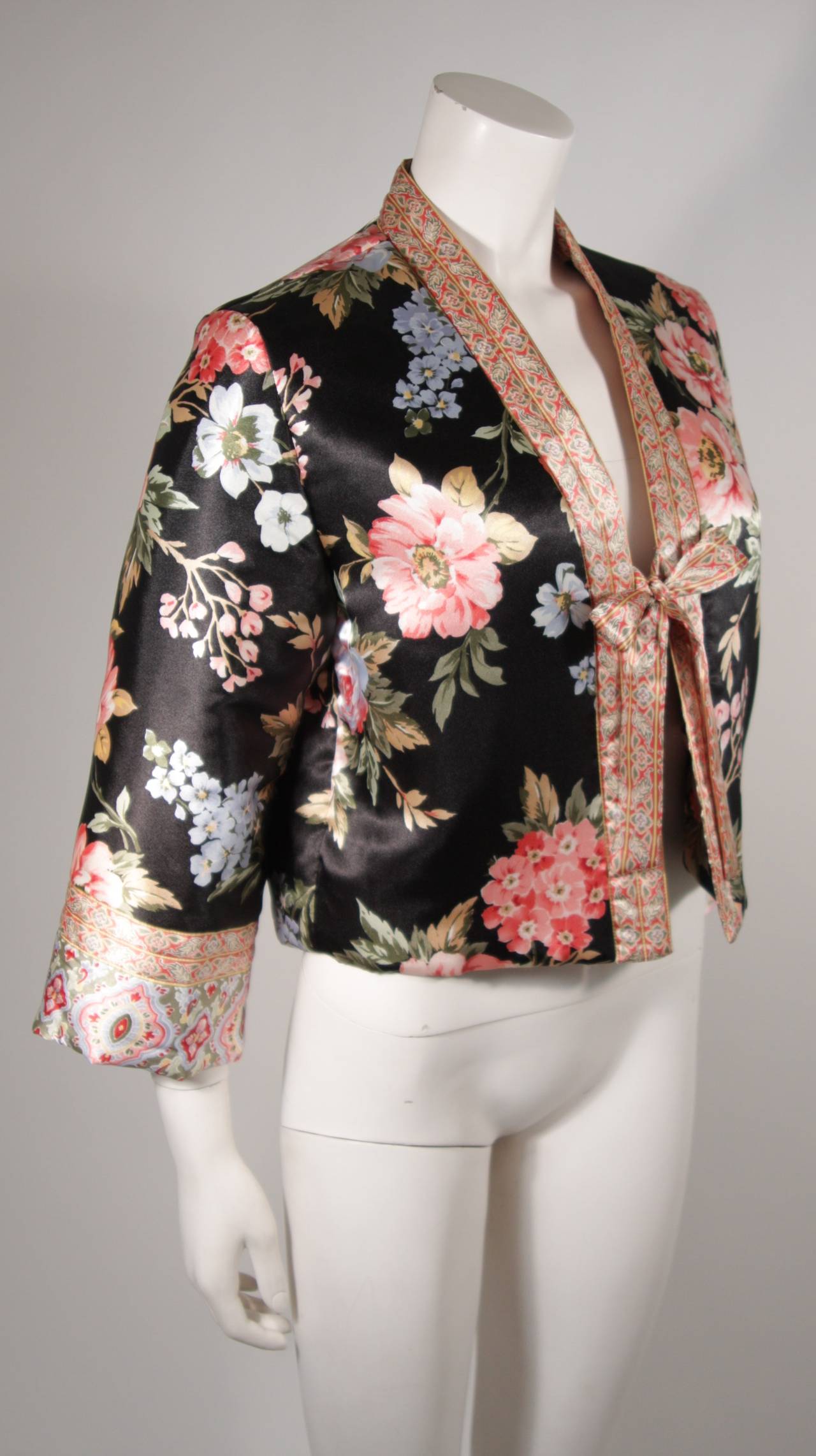 This Oscar De La Renta jacket is available for viewing at our Beverly Hills Boutique. The jacket is composed of a floral print silk. The basic tie front style is complimented by the lightweight puff design. Features one interior pocket. 

Measures