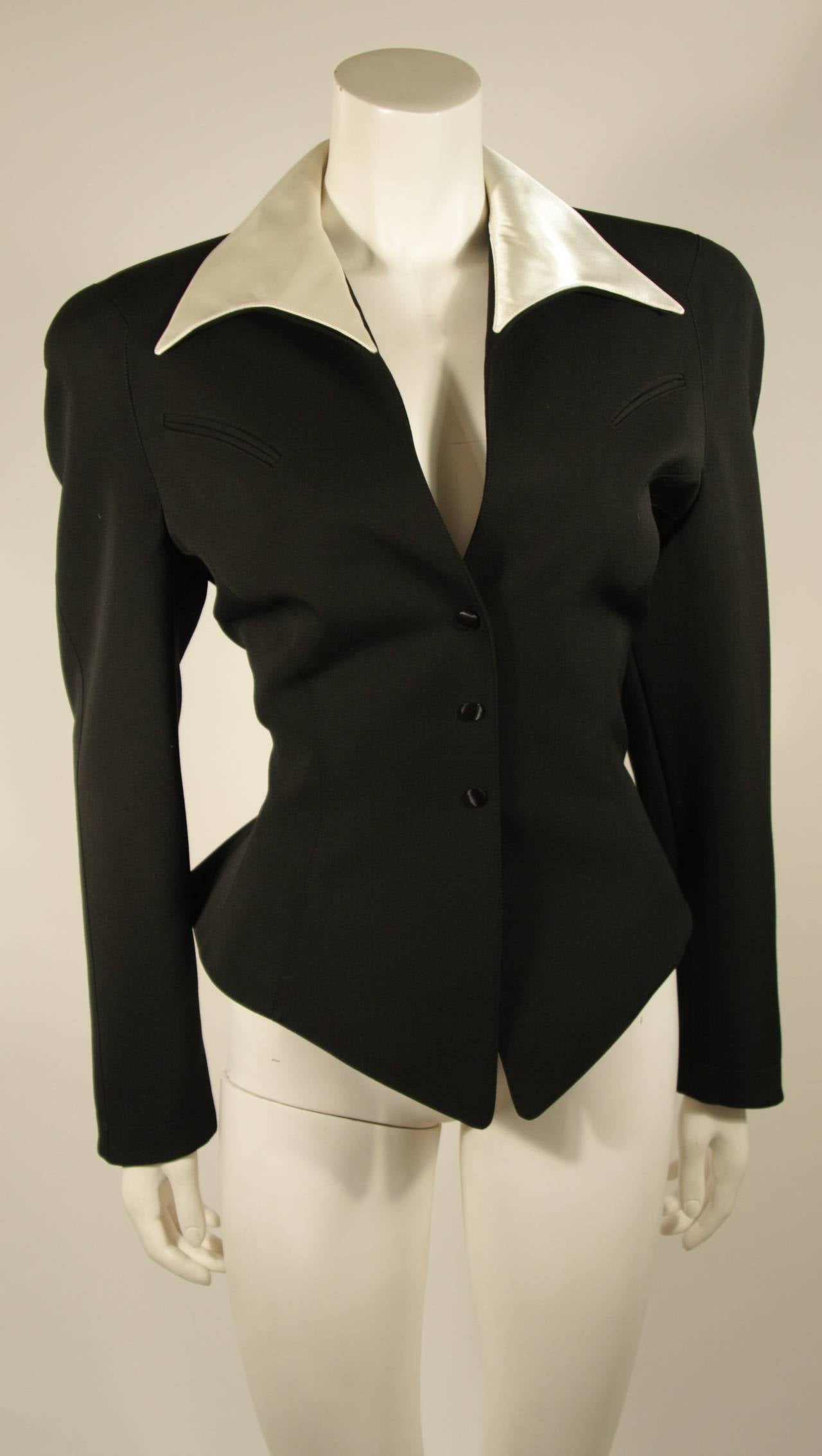 This exceptional Thierry Mugler design is available for viewing at our Beverly Hills Boutique. The jacket has a western influence. It is composed of a black fabric and features a double collar which is topped with an off white silk. Exceptional