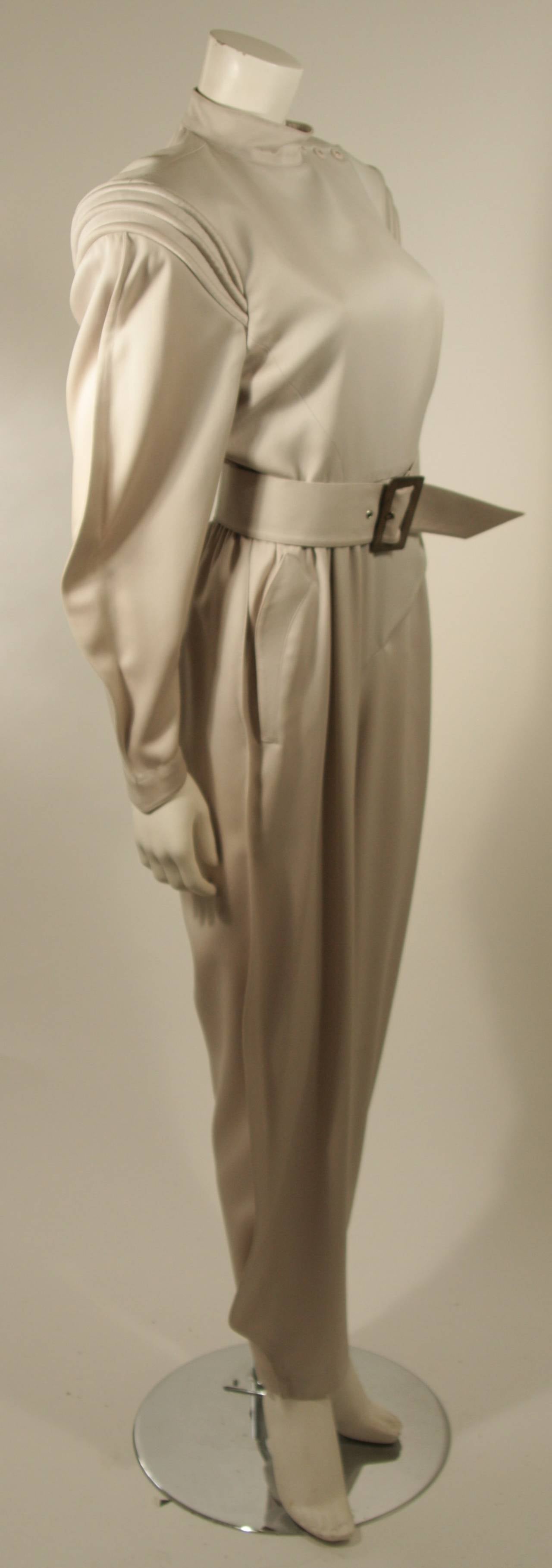 This Thierry Mugler pantsuit is composed of grey fabric which has discoloration throughout (See photographs). It is sold 