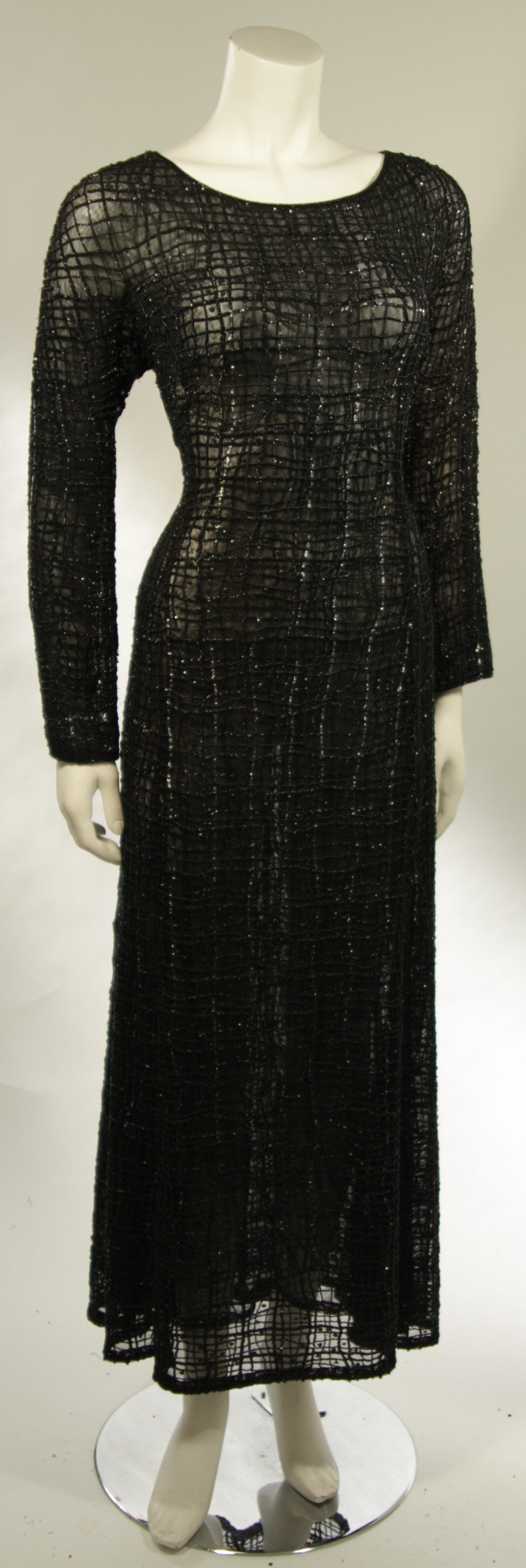 This Giorgio Armani gown is composed of a sheer black fabric with slight stretch topped with beading. Made in Italy. 

Measures (Approximately)
Size 44
Length: 52.5