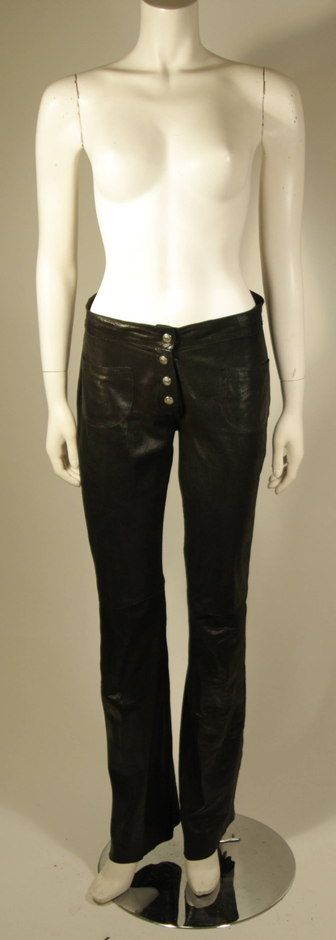 These Christian Dior pants are composed of a lightweight black suede with an oiled effect which causes a light sheen. There are two front patch style pockets and a zipper closure with top button snap and faux snap button look. Made in France.