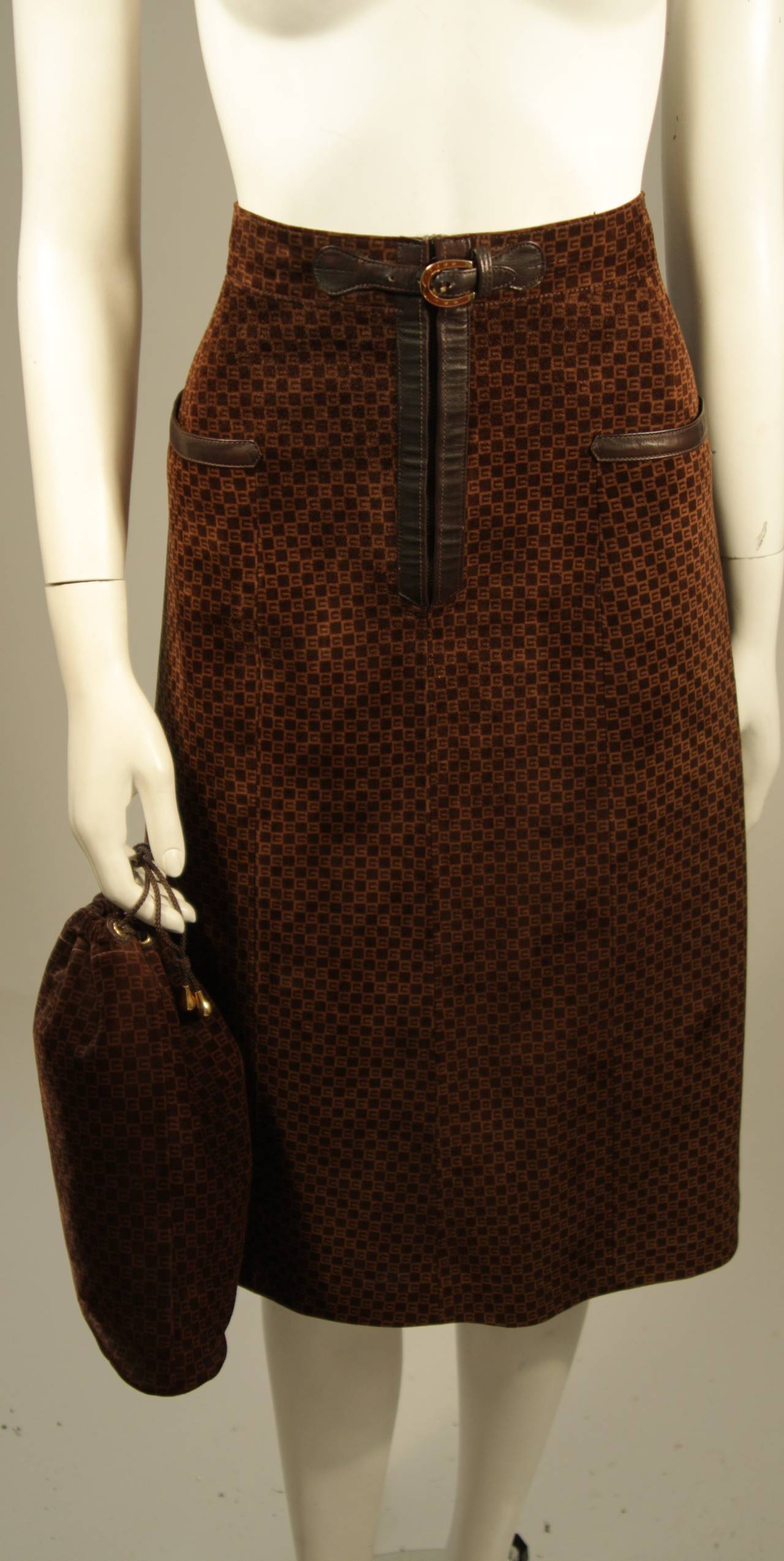 This Gucci skirt is composed of a brown suede with Gucci logo print and gold horse shoe waist buckle detail. There is a zipper closure. Photographed with Gucci purse which is sold separately, please contact us for details. 

Measures
