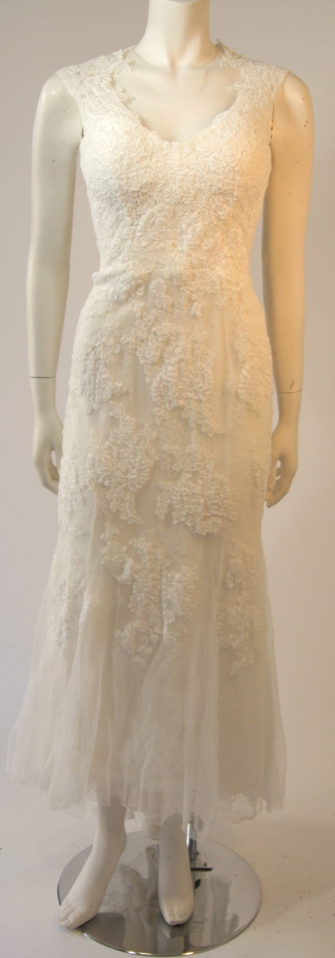 This Monique Lhuillier is available for viewing at our Beverly Hills Boutique. The gown is composed of a supple silk and mesh lace blend. There is a center back zipper closure. Comes with veil.  

Measures (Approximately) 
Length: 53
