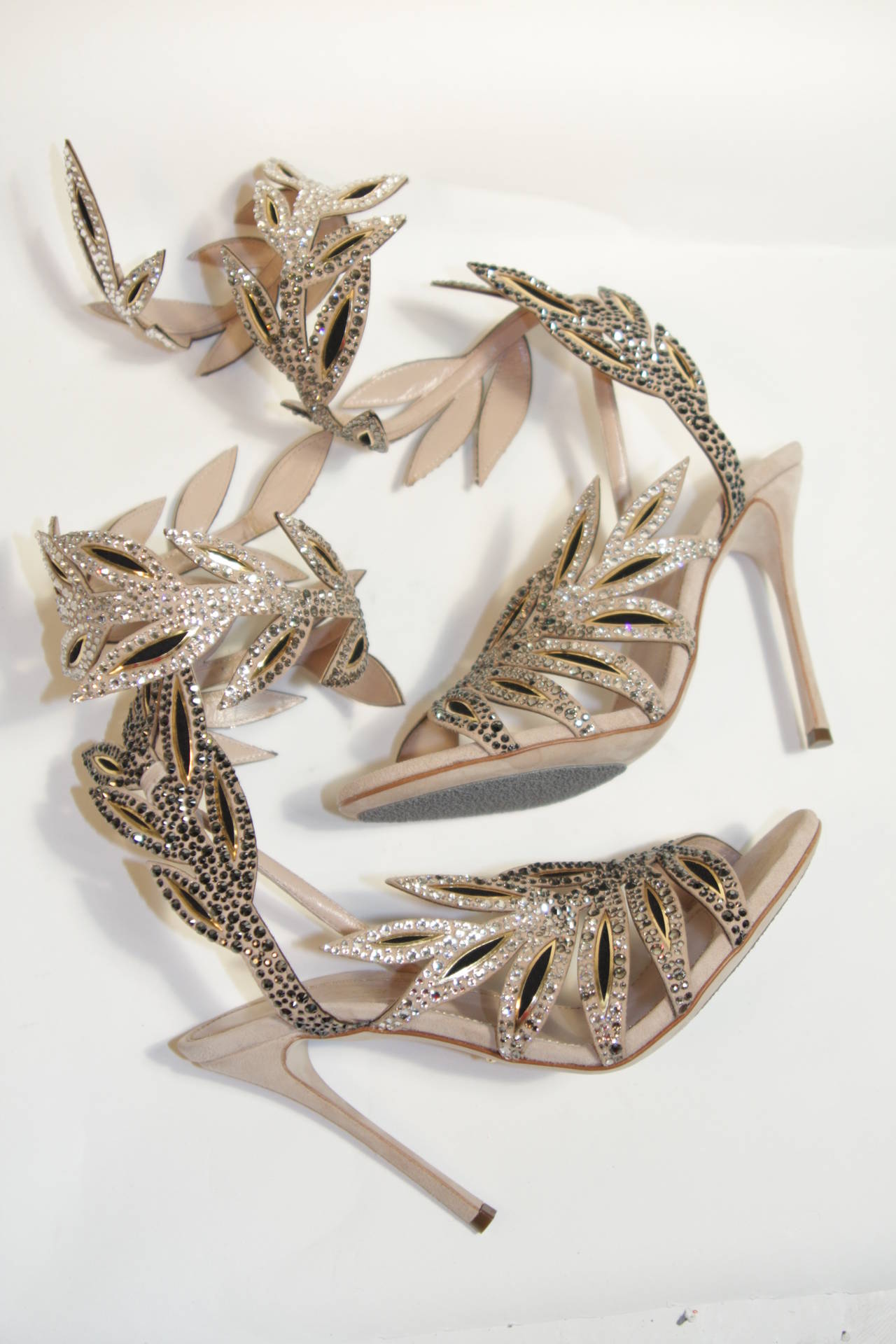 These are a phenomenal Sergio Rossi design is available for viewing at our Beverly Hills Boutique. Thes stilettos are composed of a nude suede. The heels are adorned with white and silver rhinestones and feature a striking vine silhouette which