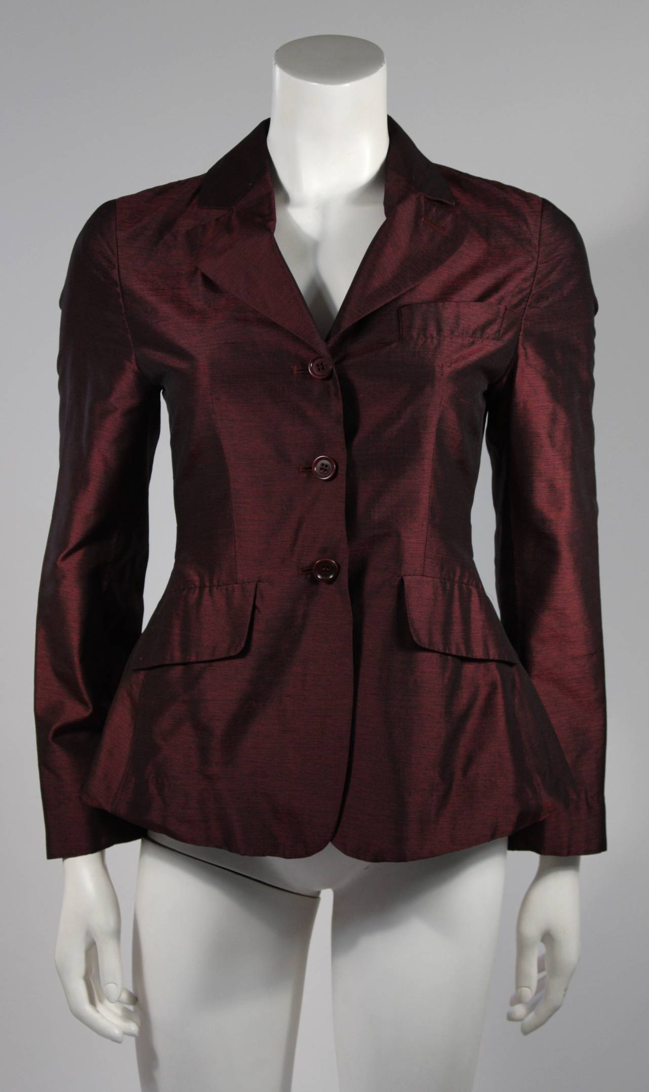 This Romeo Gigli design is available for viewing at our Beverly Hills Boutique. The blazer is composed of a beautiful burgundy (likely) silk fabric. There are three center front button closures. Made in Italy.

Feel free to inquire about our