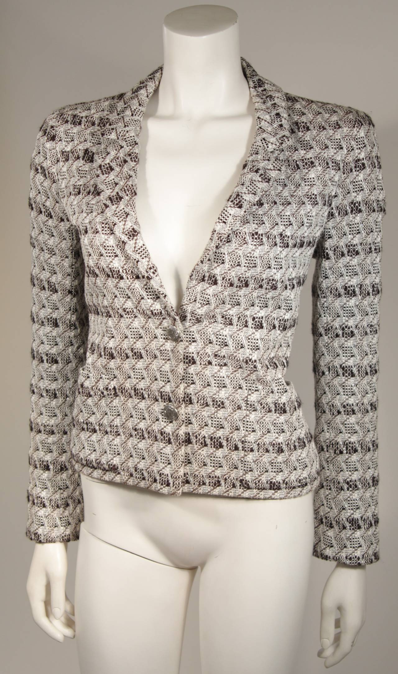 This Chanel jacket is available for viewing at our Beverly Hills Boutique. The blazer is composed of a white, black, and silver metallic fabric. There are center front button closures and two front pockets.

Feel free to inquire about our